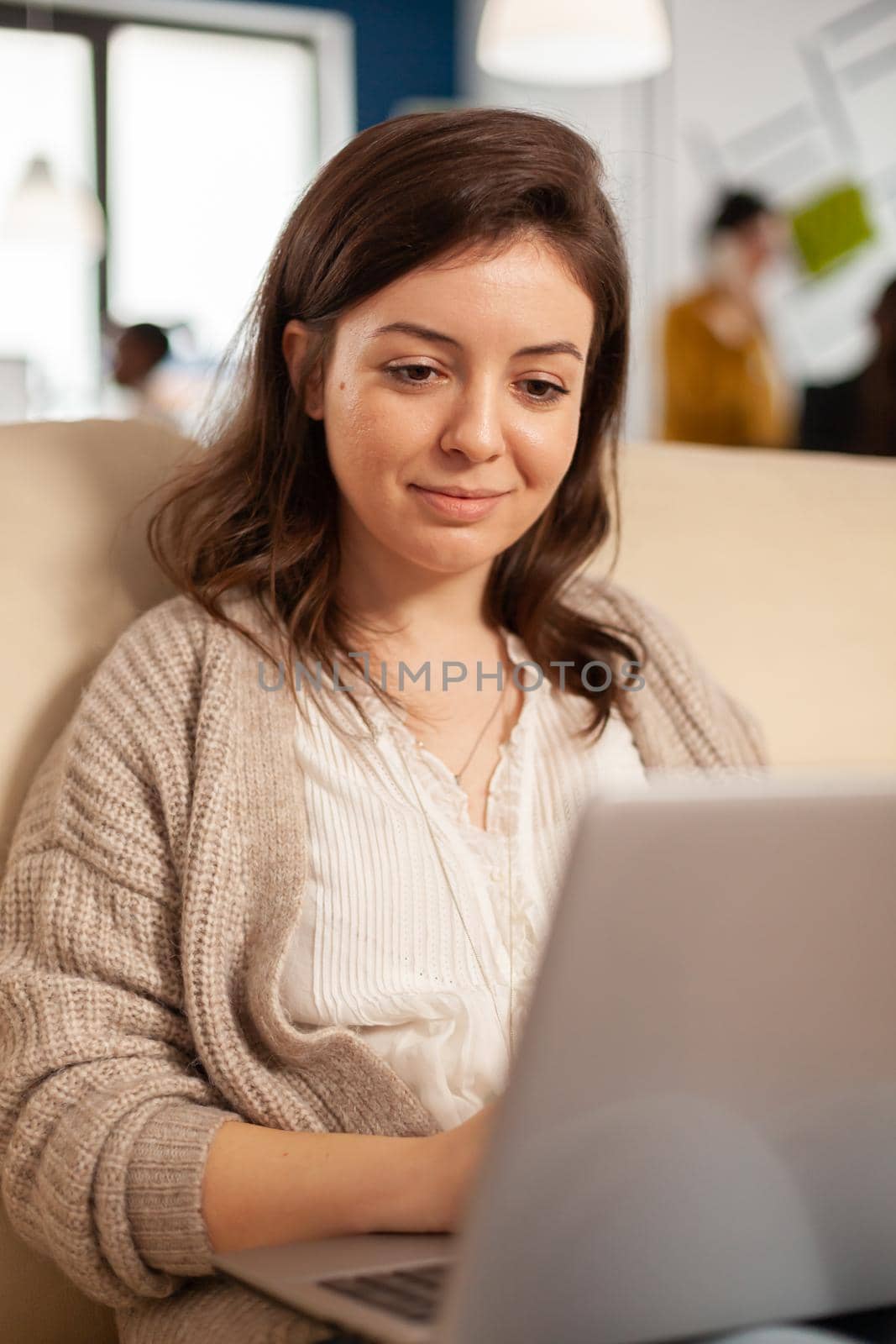 Close up of manager woman searching on laptop sitting in relax zone by DCStudio