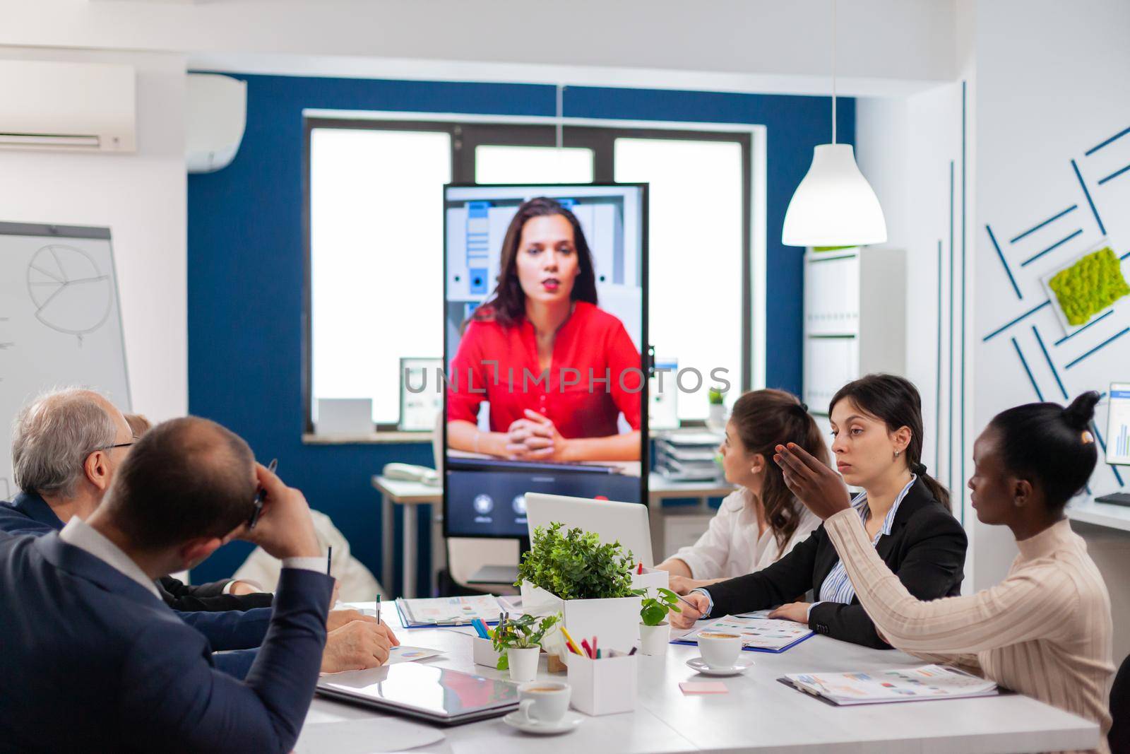 Multicultural team in financial company listening coach during online virtual training. Business people talking to webcam, do online conference participate internet brainstorming, distance office discussion