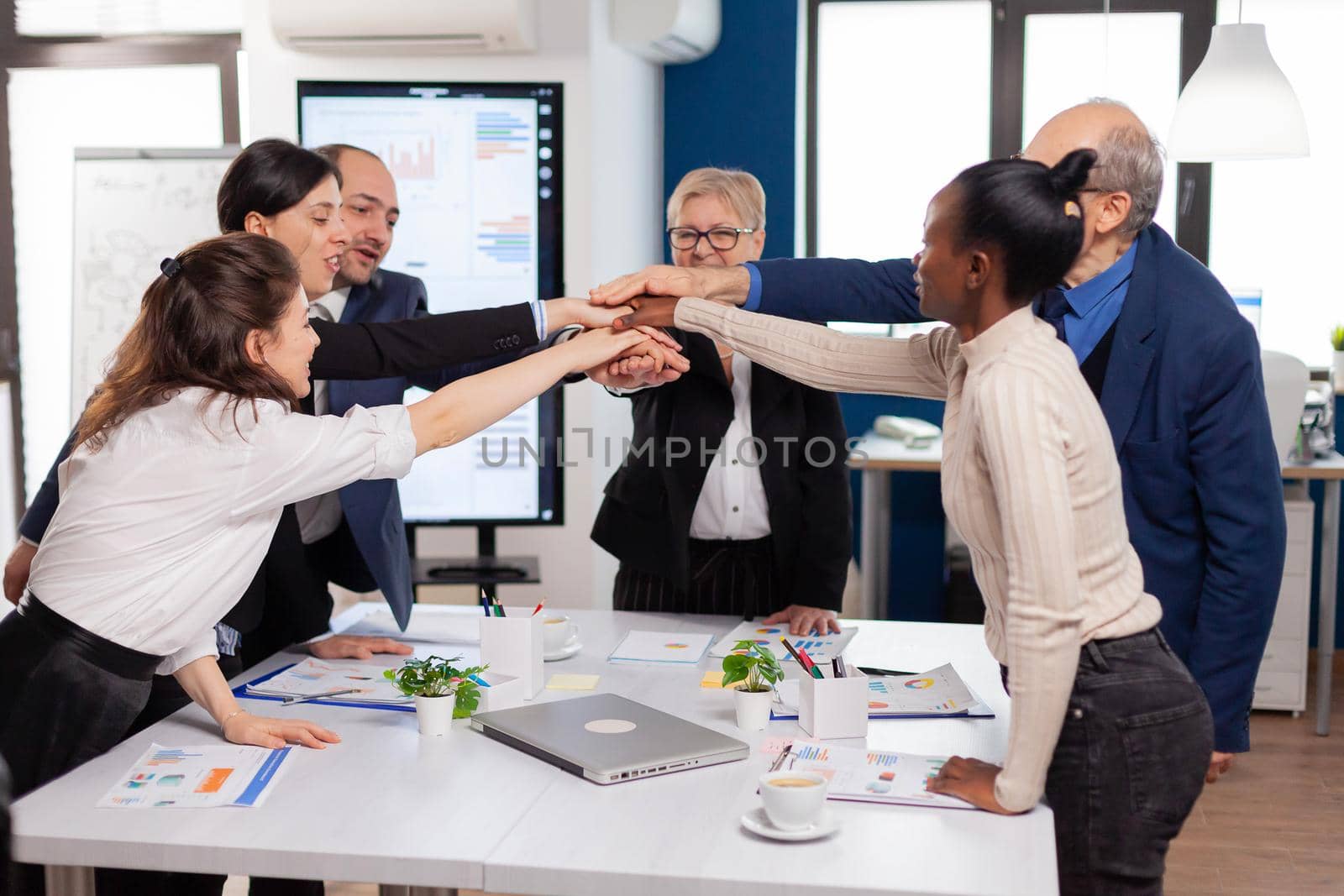 Cheerful overjoyed business people in conference room celerating Diverse colleagues with new opportunity enjoing victory meeting in broadroom office.