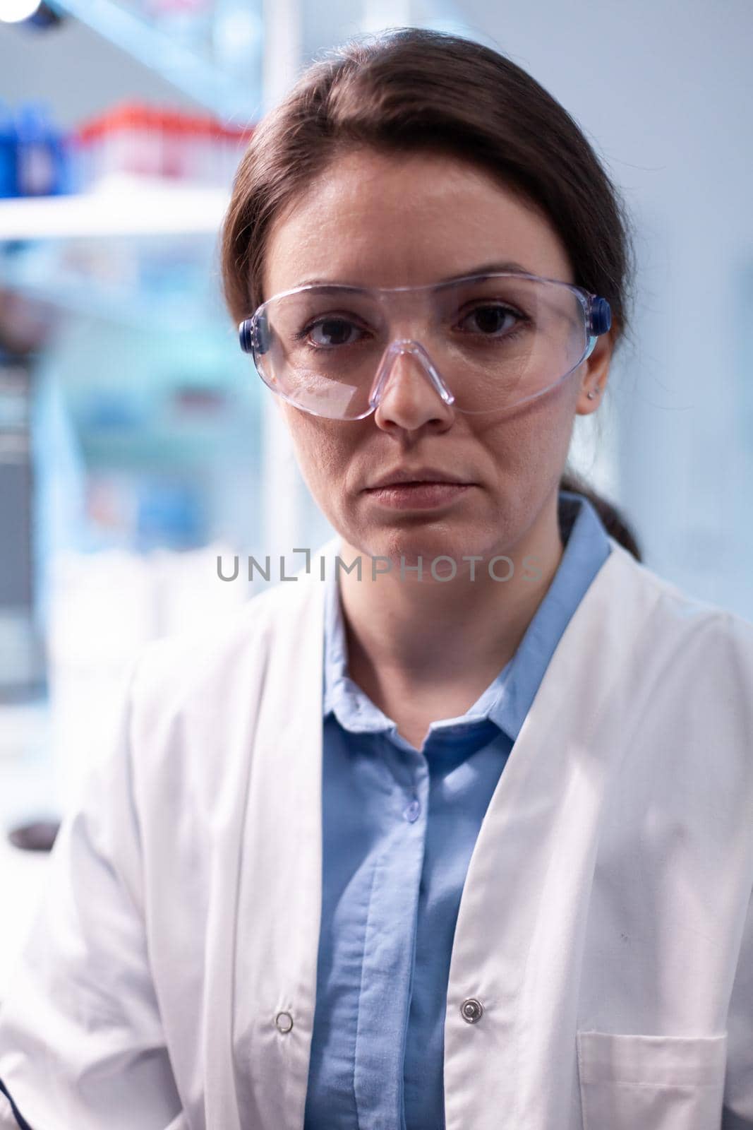 Woman researcher in science laboratory looking at camera. Doctor in chemistry biology medicine lab working with professional technology equipment