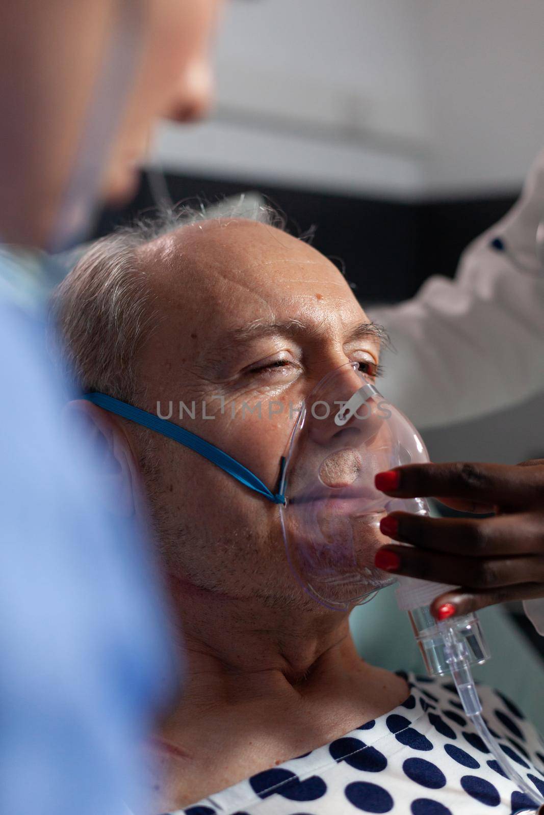 Side view of senior patient breathing assisted by respiratory tube by DCStudio