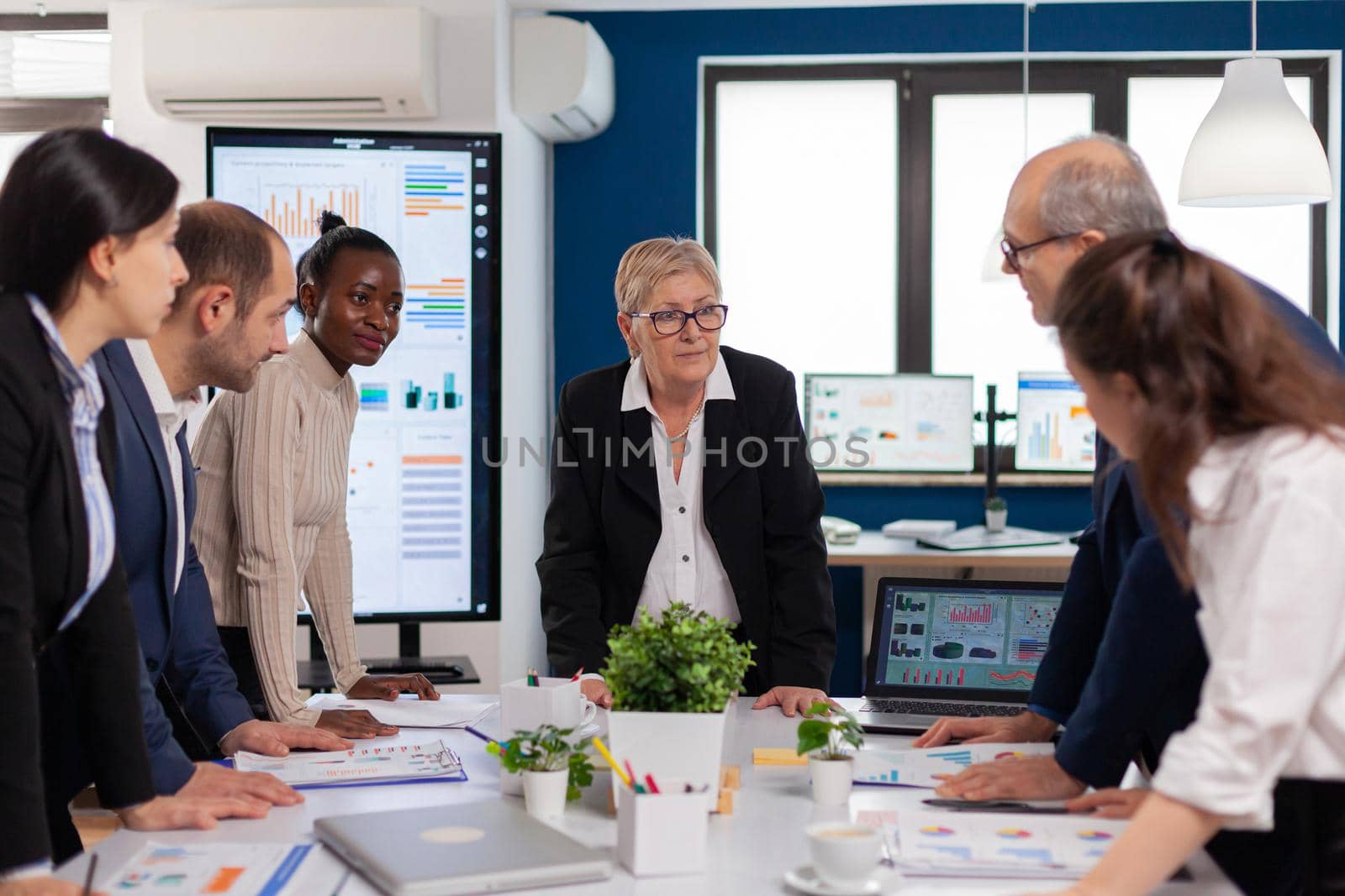 Diverse colleagues businesspeople discussing company issue during start up meeting sitting in broadroom office. Multiethnic colleagues working planning success financial strategy discussing in office.