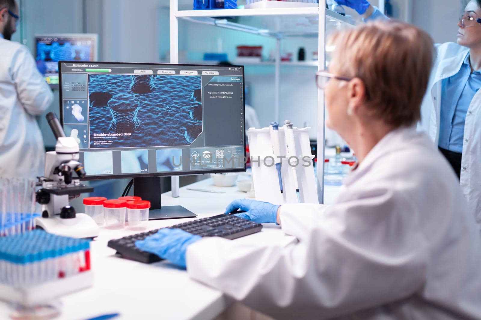 Medical scientist analyzing a test into computer for hospital expertise. Professional senior doctor examining vaccine evolution using high tech for scientific research, treatment development against covid19