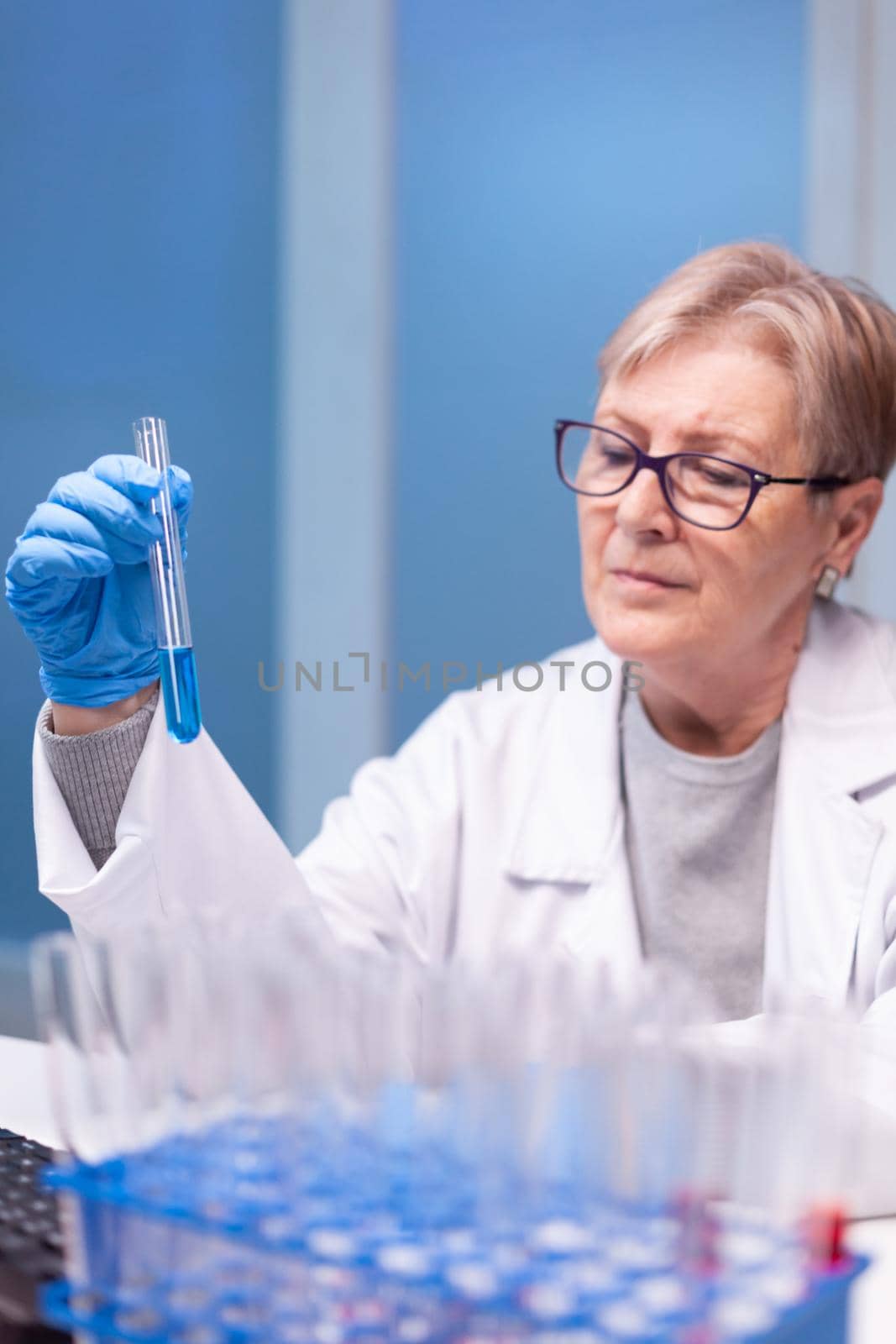 Senior doctor discovering genetic infection and analysing a test tube for medical expertise. Pharmaceutical scientist in research laboratory work with professional technology equipment for healdcare development