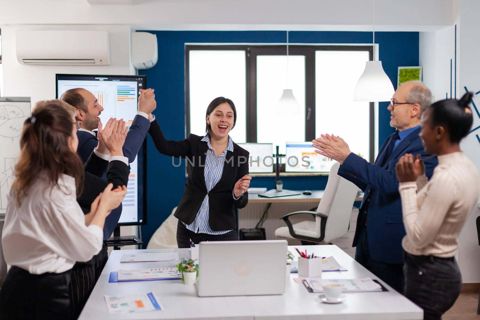 Corporate business team achieving success concept for startup in conference room victory, winners. Multiethnical partners coworkers celebrate successful teamwork result at company briefing
