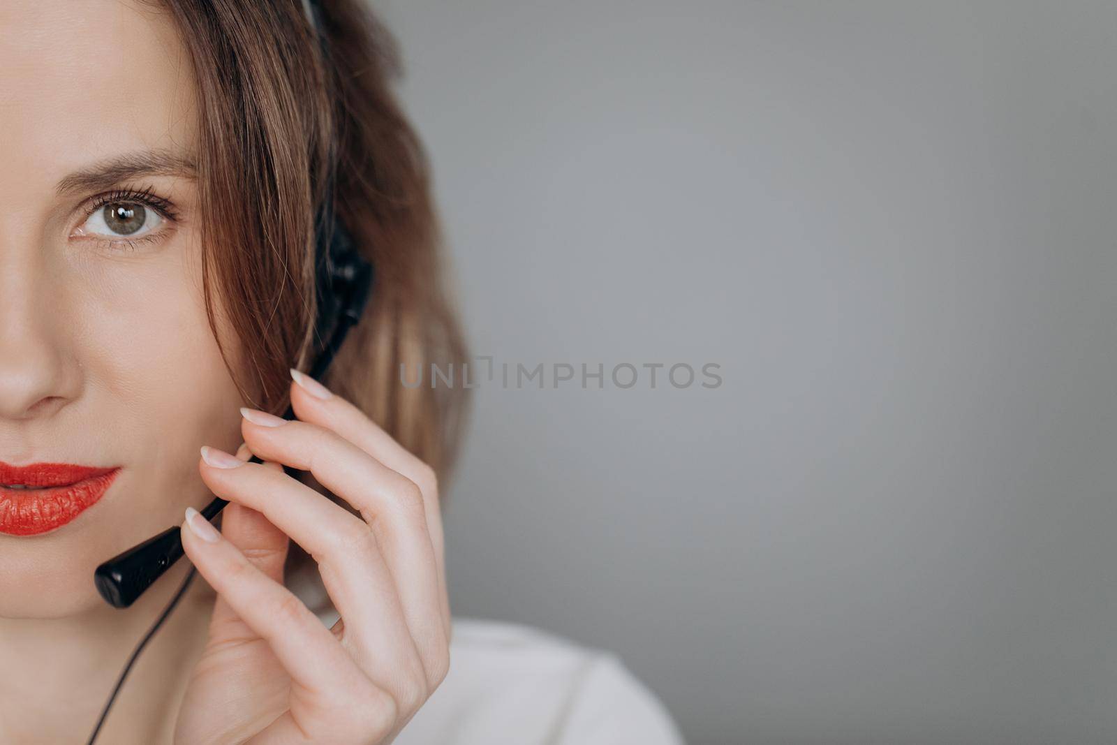 Female customer support operator with headset. Portrait of cheerful support phone operator in headset, isolated on gray background. by uflypro