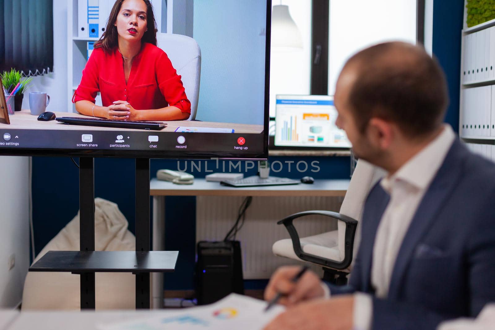 Executive manager discussing with remote colleagues on video call sitting in business office Business people talking to webcam, do online conference participate internet brainstorming, distance office discussion.