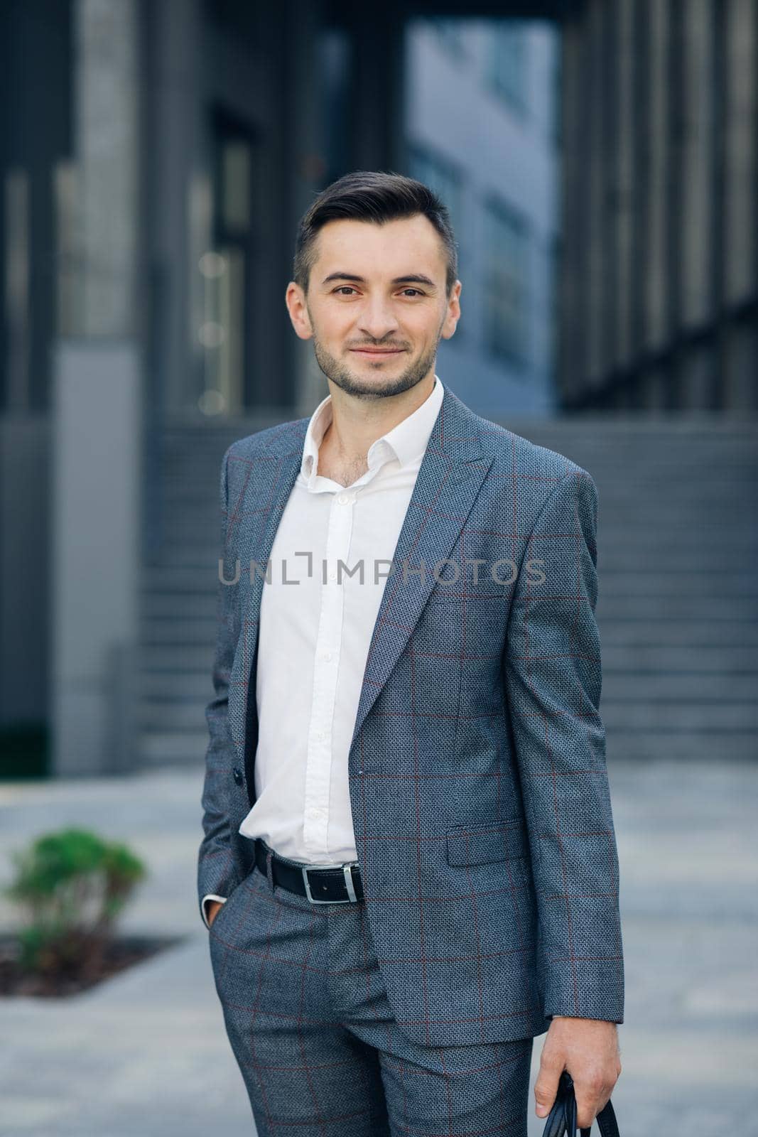 Young manager smiling in a modern office. Portrait of an handsome businessman. by uflypro