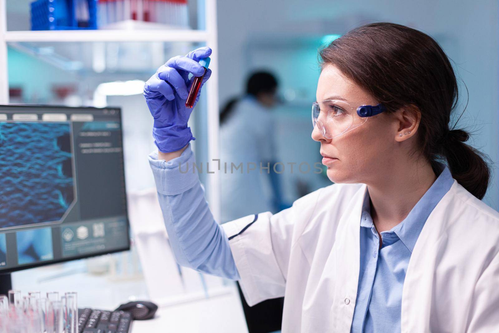 Biotechnologist doctor analysing a blood tube for medical investigation. Researcher in chemical medicine lab working with professional technology equipment for healdcare development