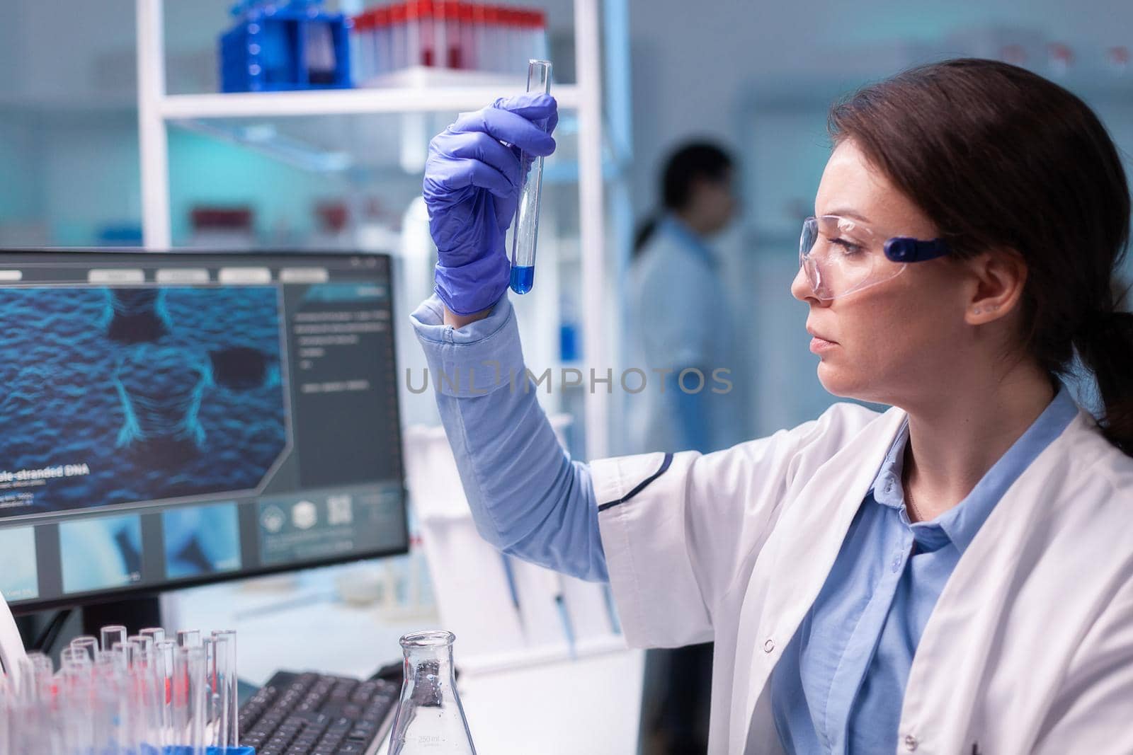 Concentrated professional woman scientist in laboratory working with test tube. Biology doctor discovery scientifc experiment with professional technology equipment industry