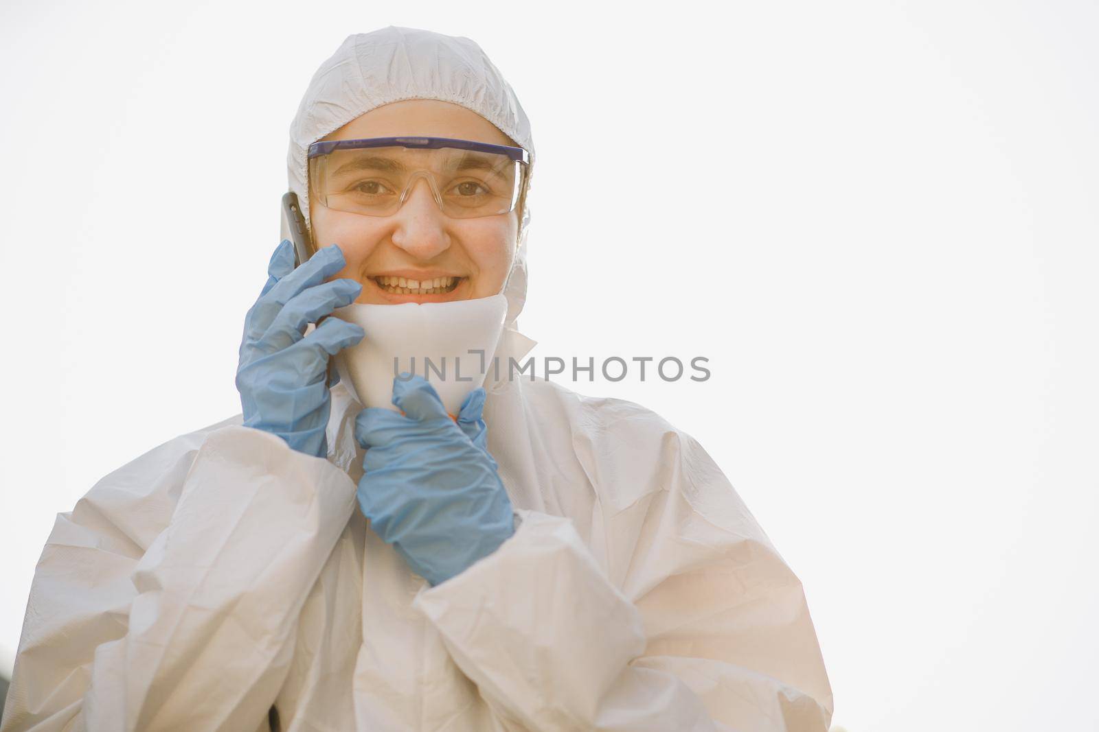 Worker in chemical protective suit on a white background. Medical worker portrait, Confident Asian doctor in protective PPE suit wearing face mask and eyeglasses. by uflypro