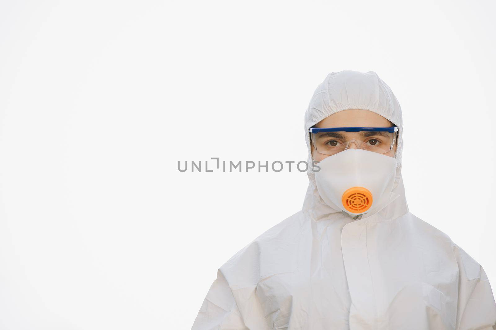 Female doctor in protective suit, face mask and red glasses. Paramedic upset woman on white background. Worker in chemical protective suit by uflypro