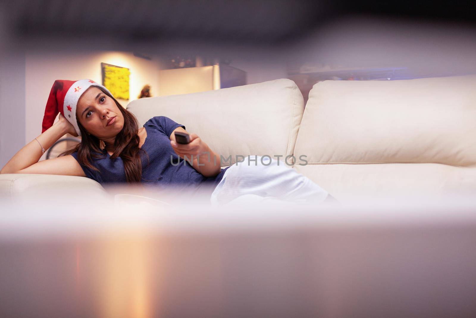 Woman adult resting on couch watching xmas movie on television by DCStudio