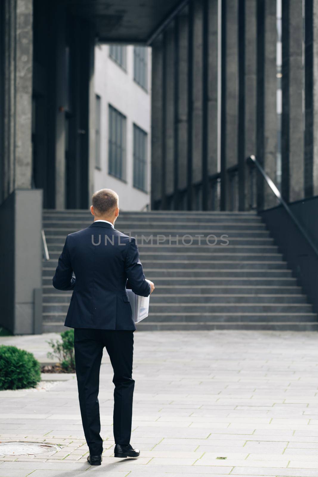 Excited man trainee new employee on first day at work carrying box with stuff to his new workplace. Concept of work,career and success by uflypro