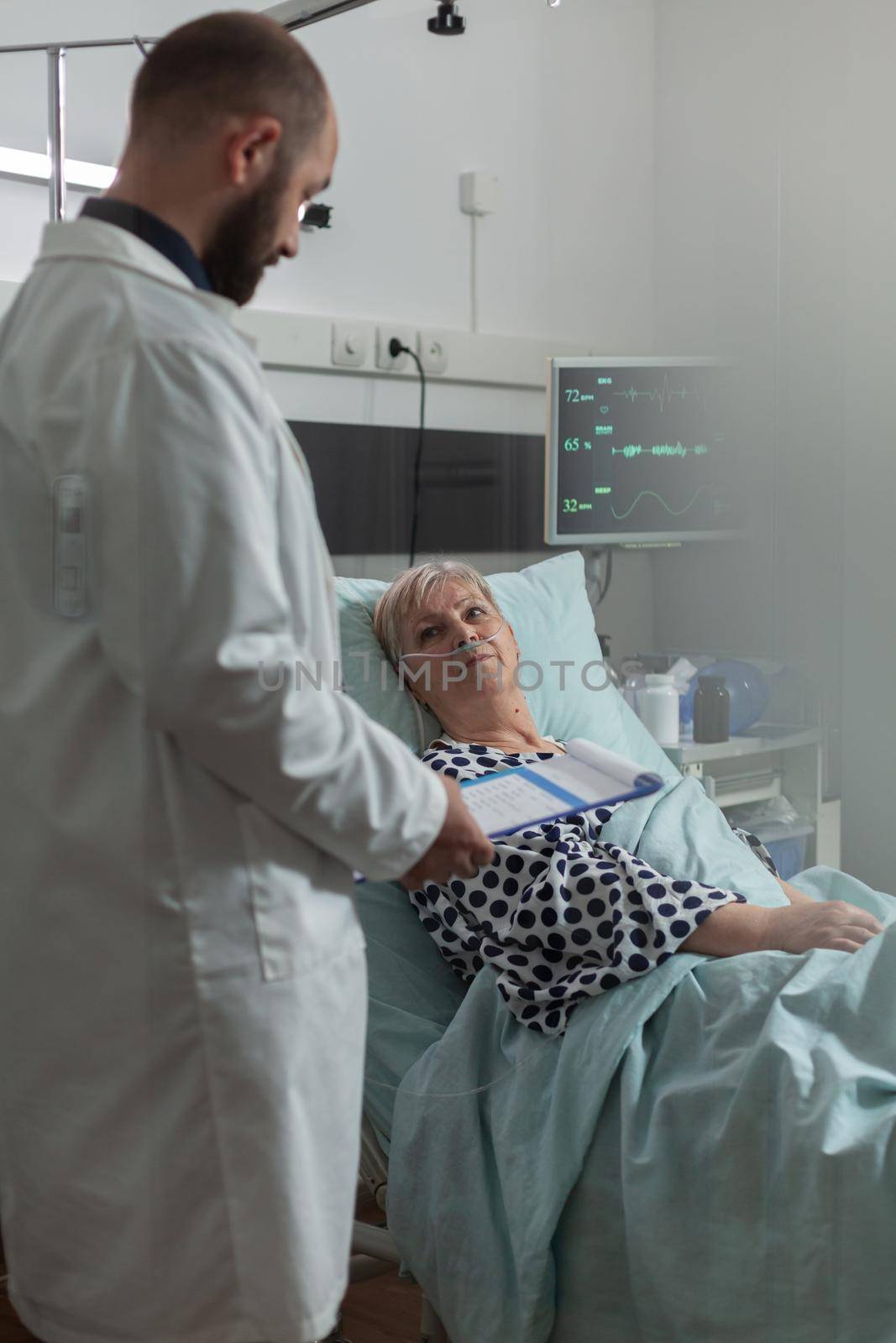 Doctor reassuring senior woman full recovery during discussion by DCStudio