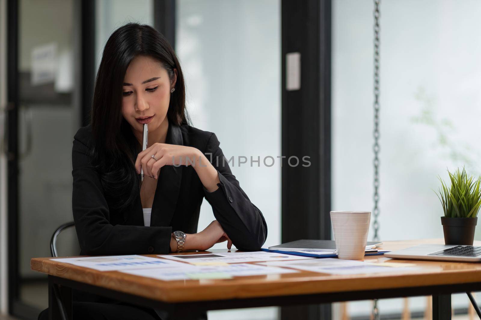 Portrait Of Attractive Asian Businesswoman Working for marketing plan. business analysis,financial services,financial planning, by nateemee