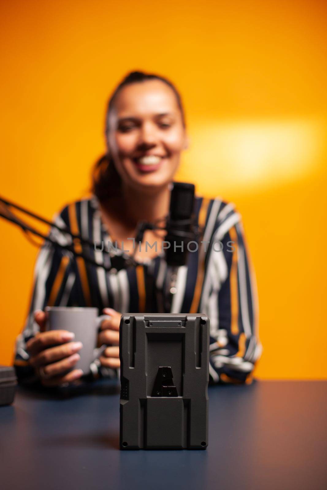 Videographer filming battery with v-lock during podcast. Professional videography gear review by content creator new media star influencer on social media.