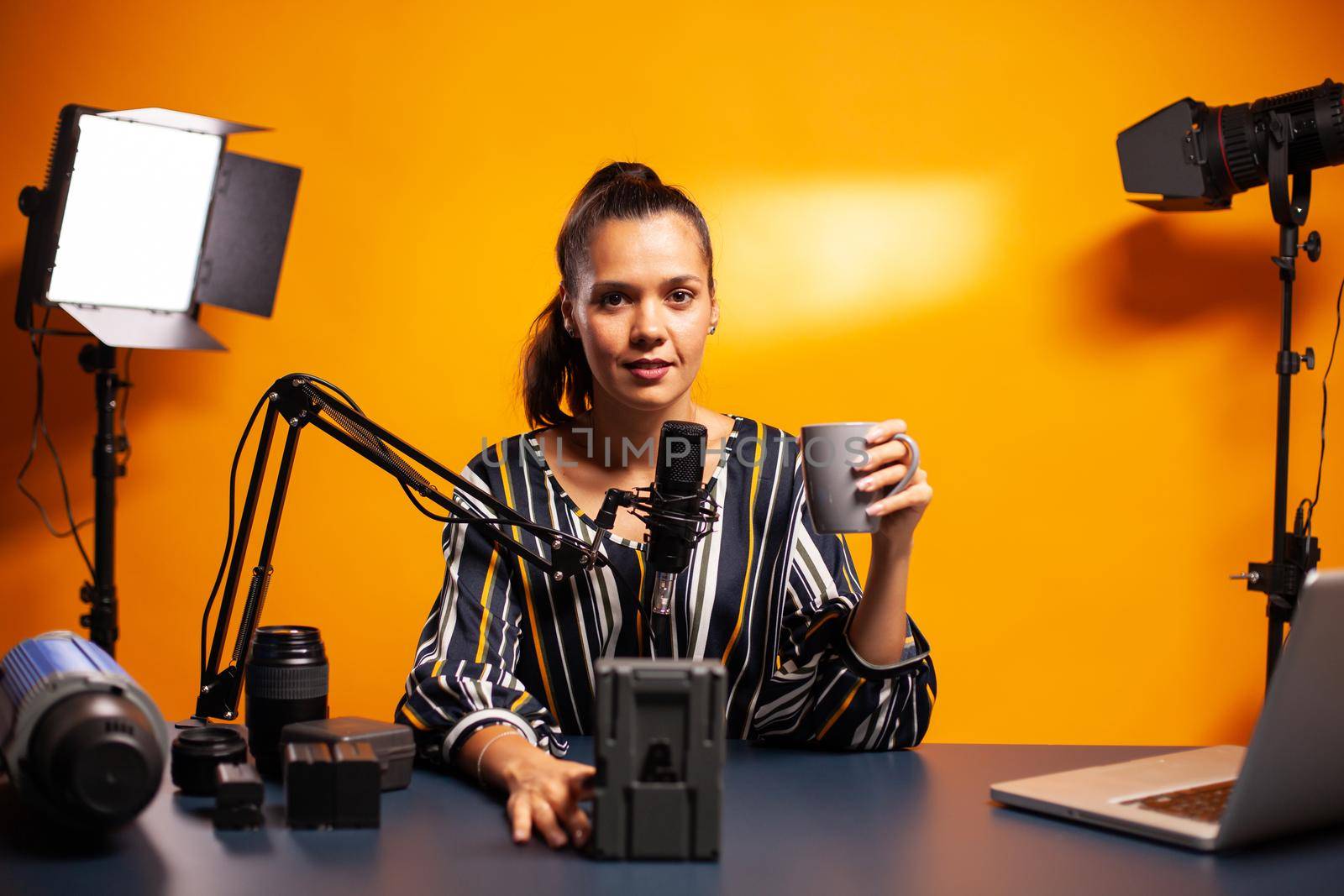 Blogger recording battery review for his podcast in home studio. Professional videography gear review by content creator new media star influencer on social media.