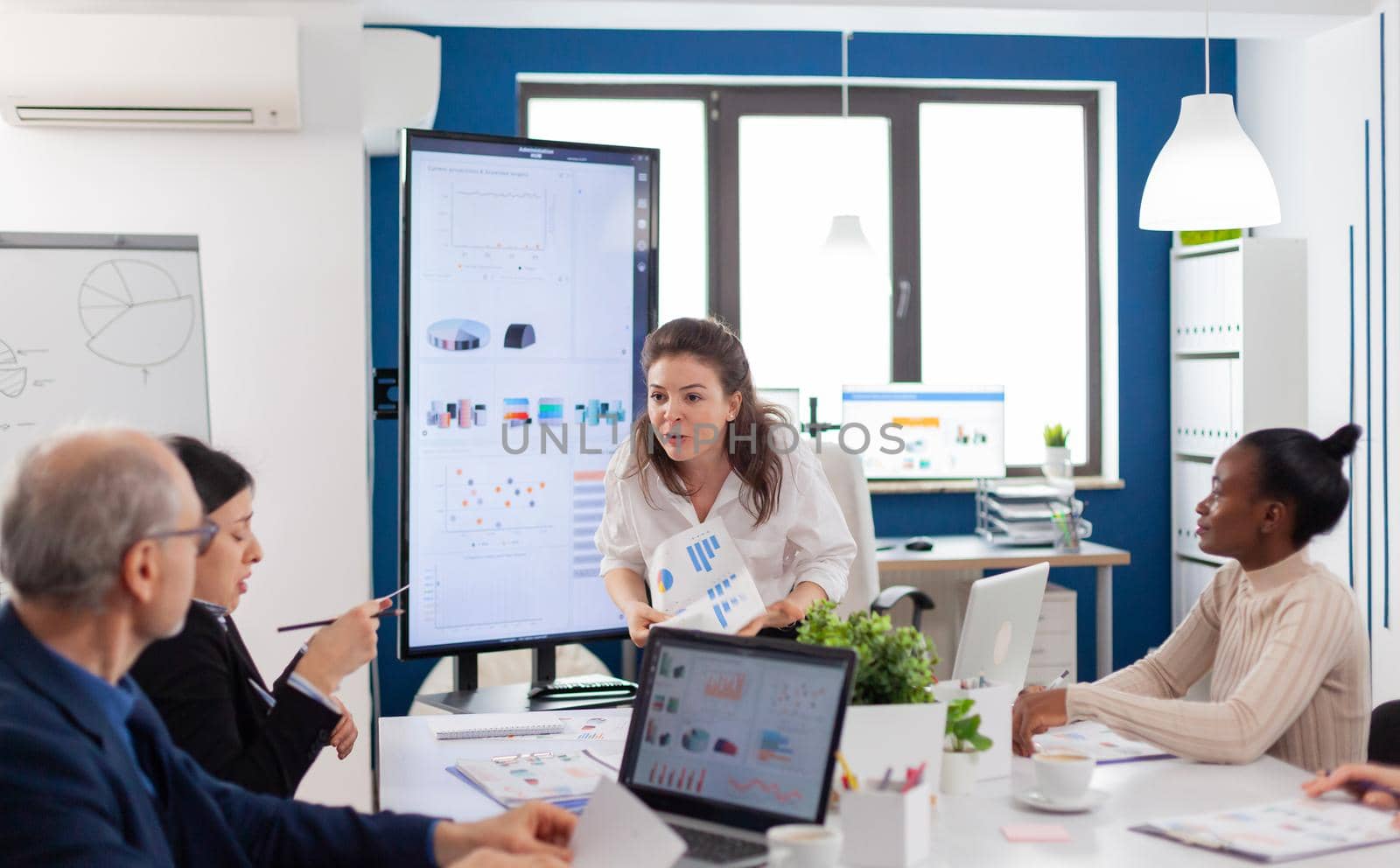 Mad angry start up owner debating screaming vivaciously in briefing asking for explication from diverse employees. Businesswoman raging about multitasking difficult job, screaming in boardroom