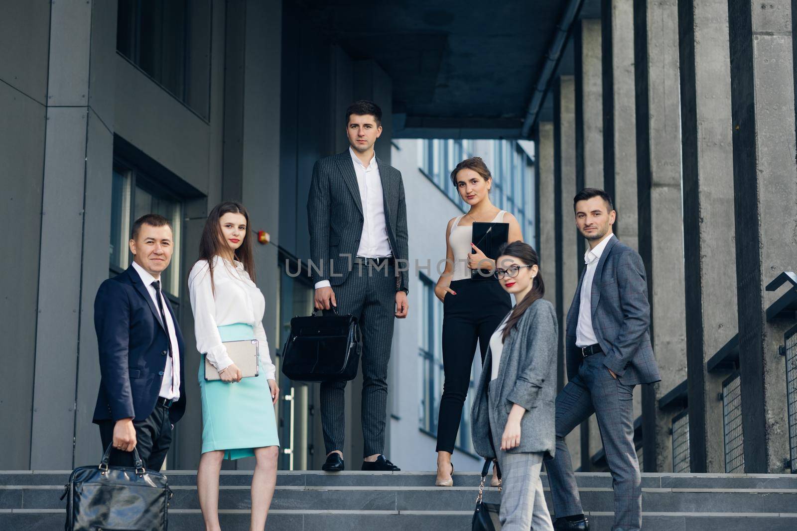 Portrait of successful creative businessman and businesswoman wear formal suits looking at camera and smiling in modern office workplace. Diverse male and female standing together.