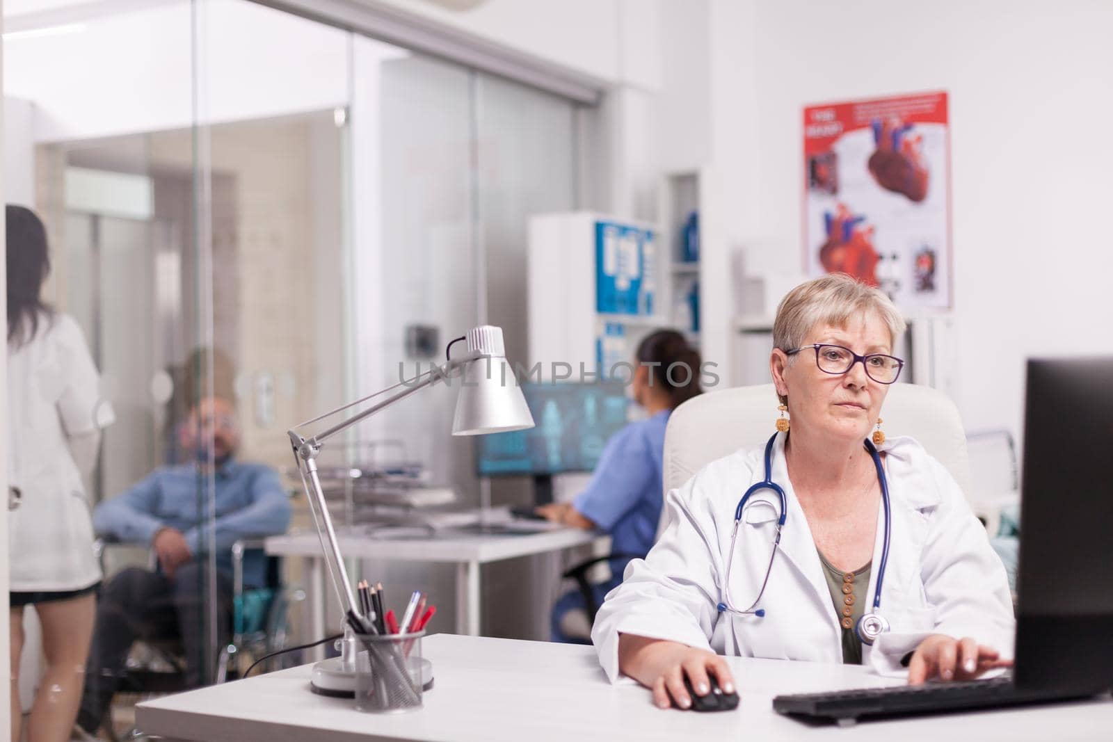 Senior woman doctor working on computer by DCStudio