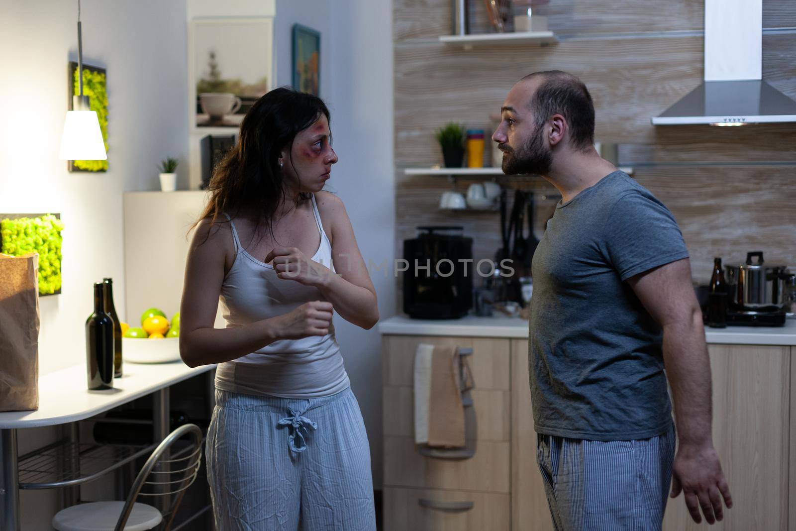 Angry man and woman dealing with domestic conflict while yelling and arguing. Wife with bruises on face and furious violent husband fighting and shouting. Physical violence and aggression