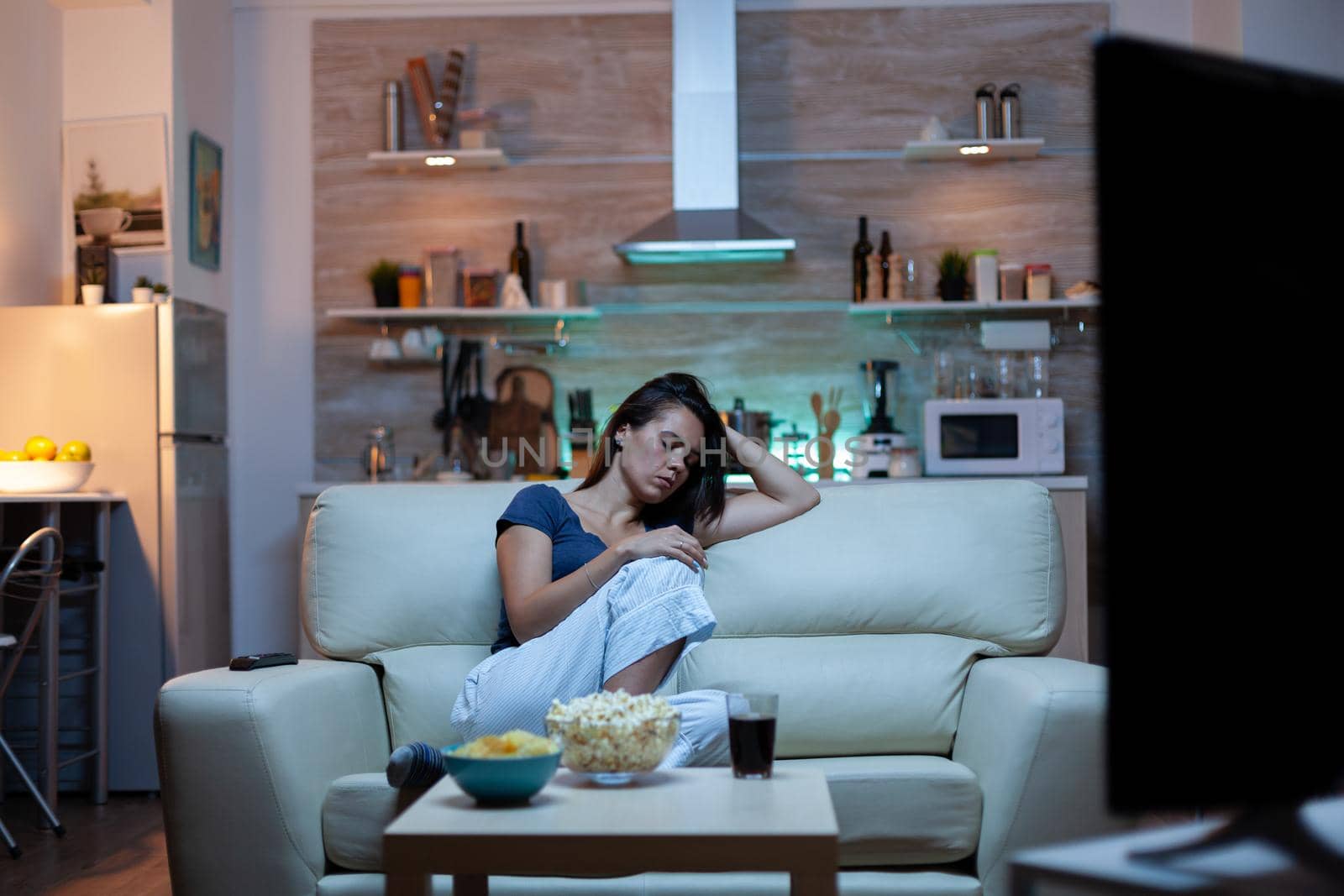 Tired housewife falling asleep in front of TV by DCStudio