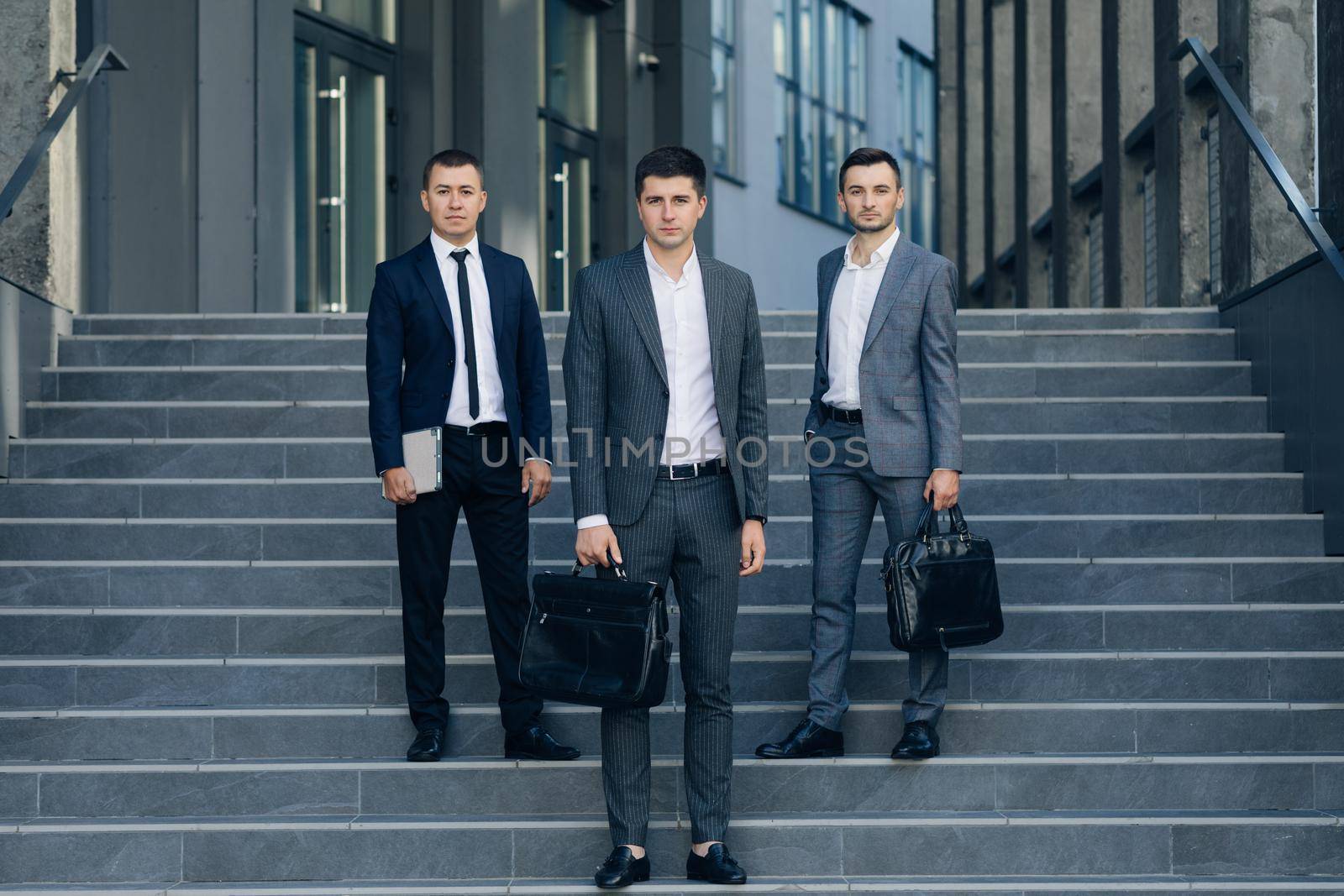 Successful work. Three successful and confident businessman standing on the steps. Businessmen in suit.