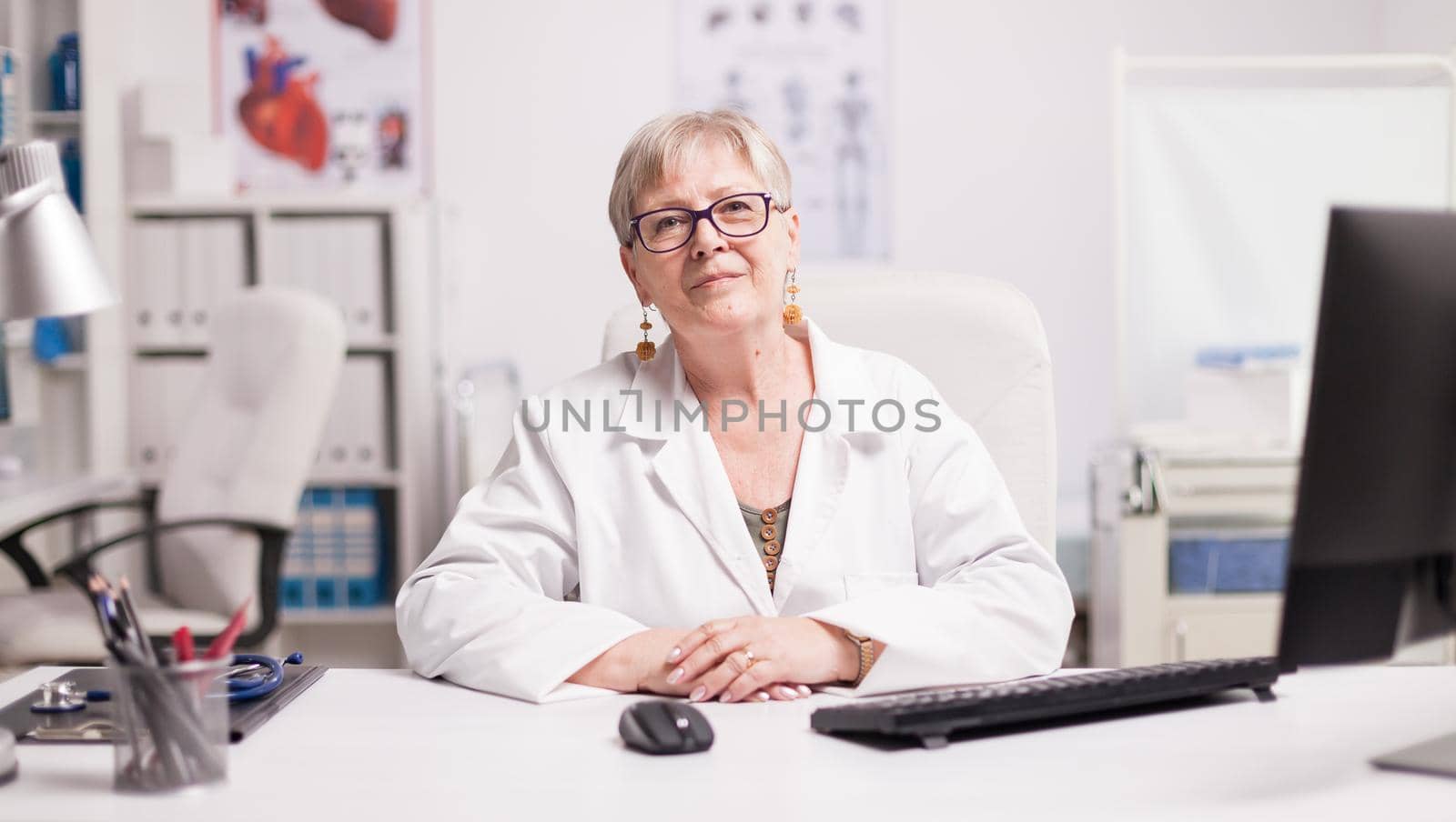 Confident senior female doctor by DCStudio