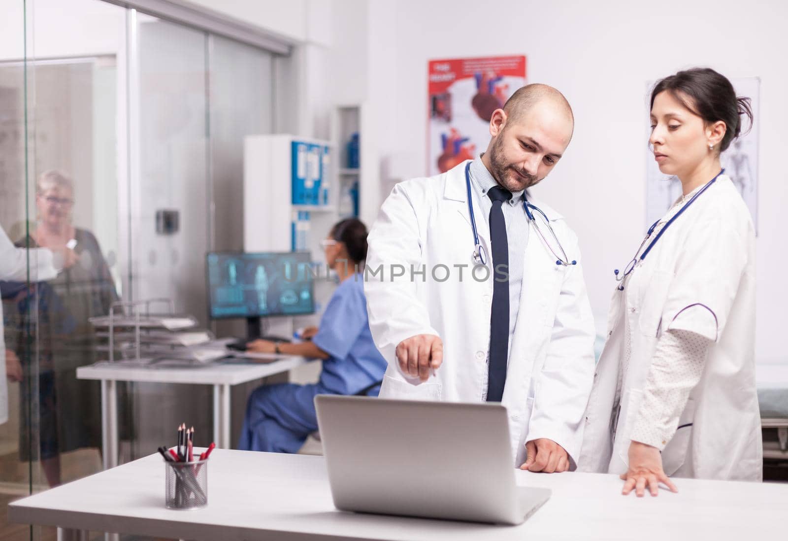 Young doctors pointing at laptop screen by DCStudio