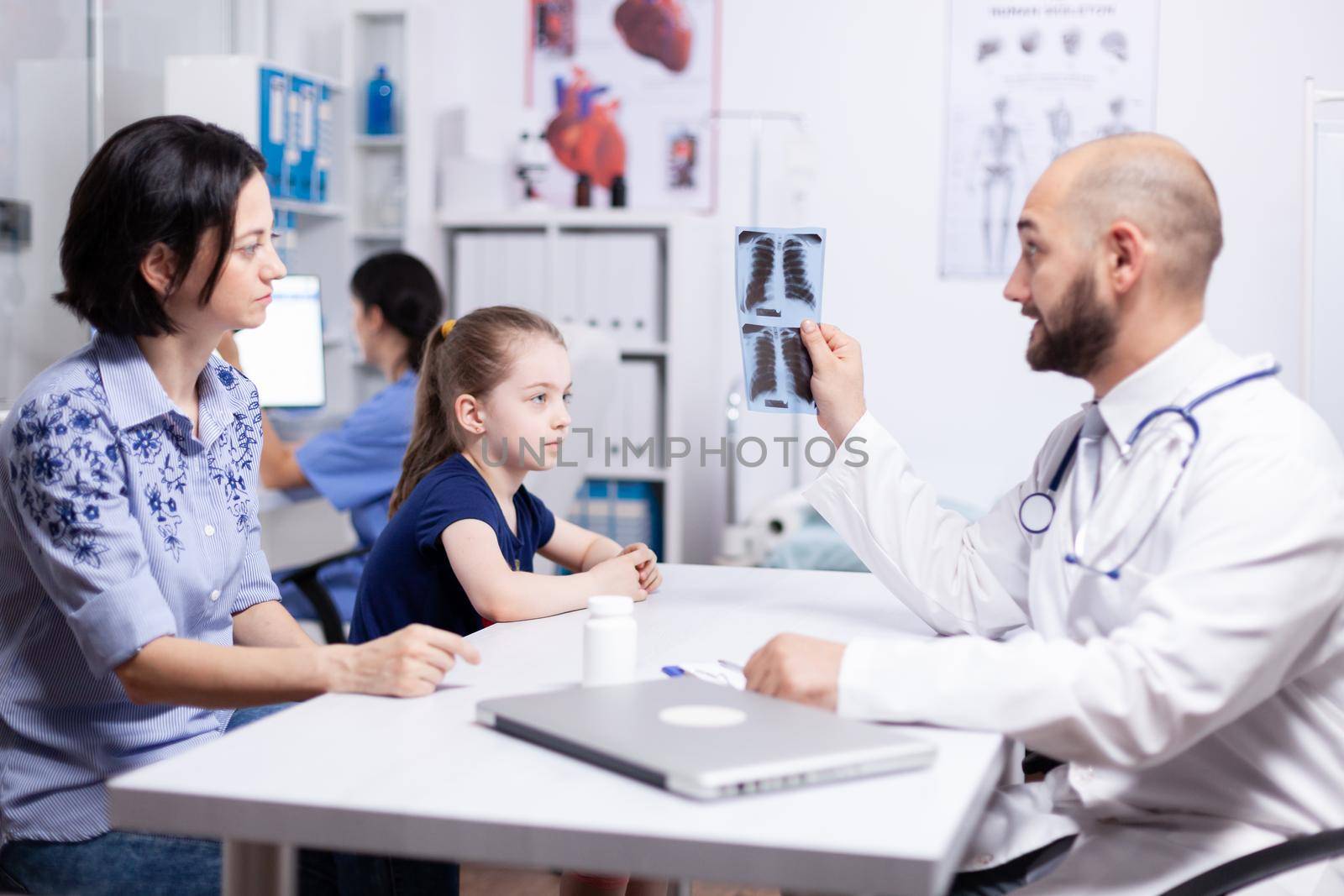 Pediatrician examining radiography by DCStudio