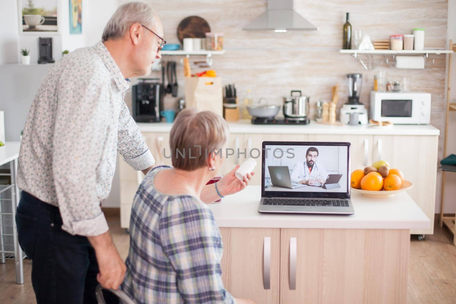 Senior woman showing pills bottle to doctor during video telemedicine conference. Online health consultation for elderly people drugs ilness advice on symptoms, physician telemedicine webcam. Medical care internet chat