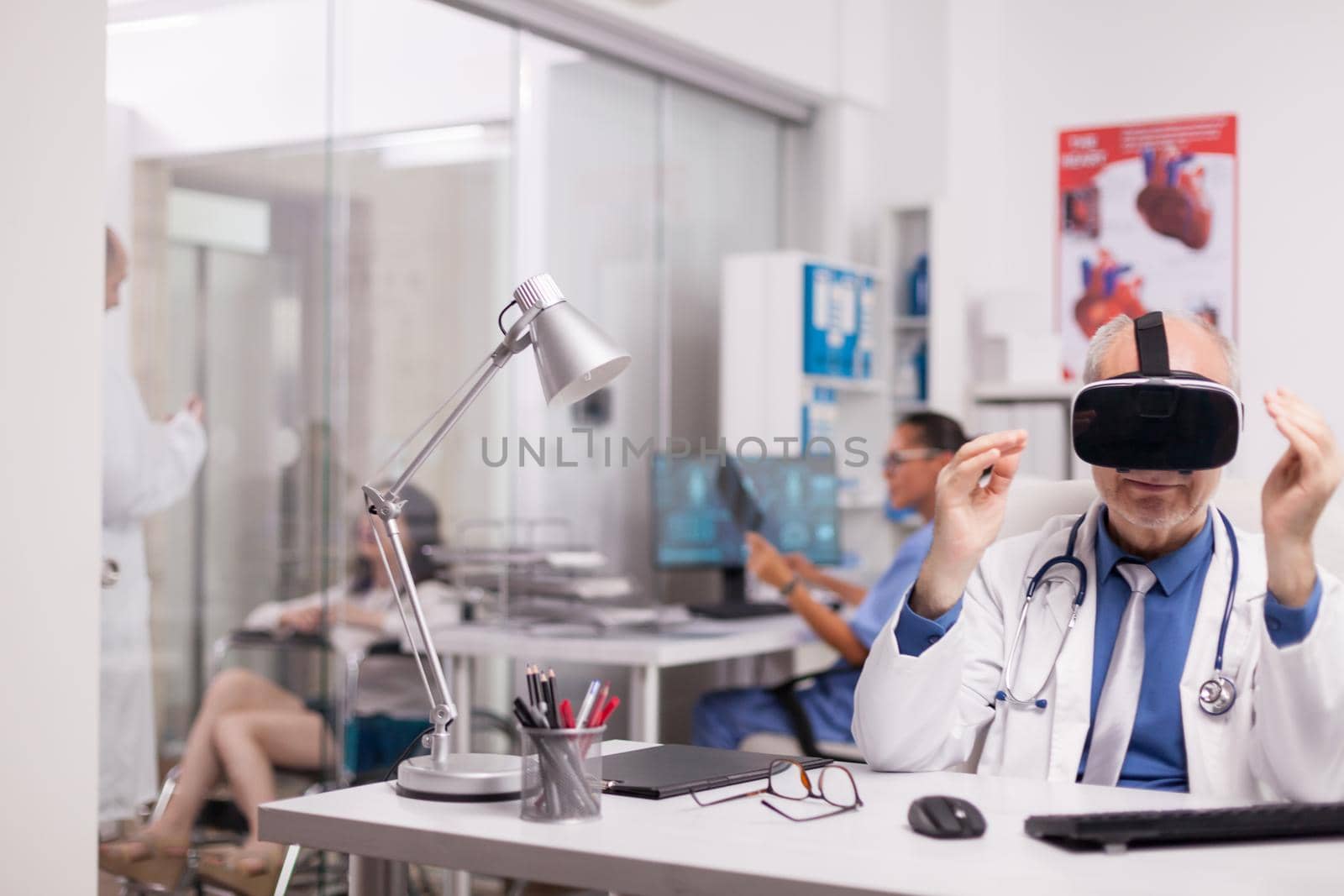 Elderly aged doctor using virtual reality goggles by DCStudio