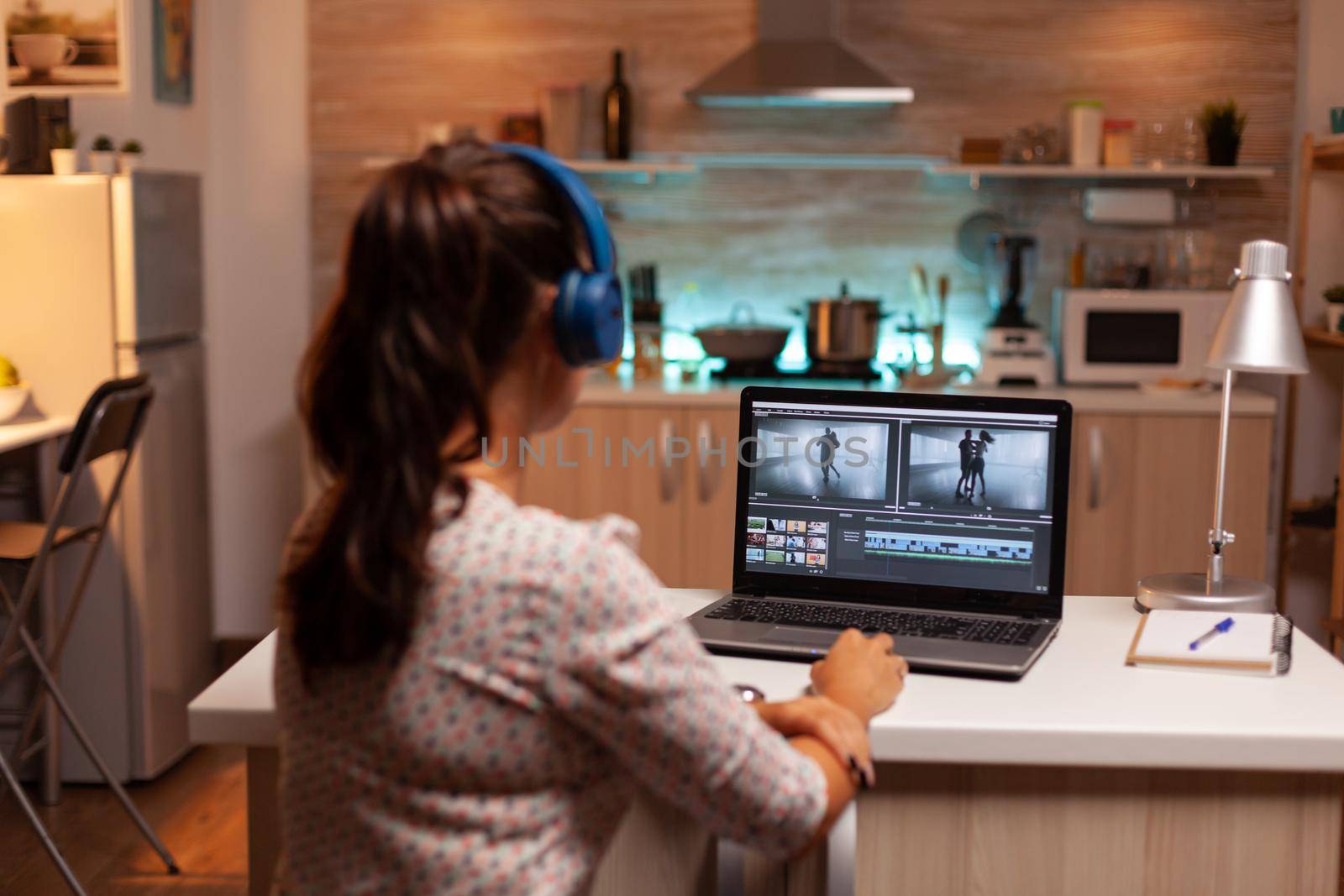 Woman working with video footage on laptop by DCStudio