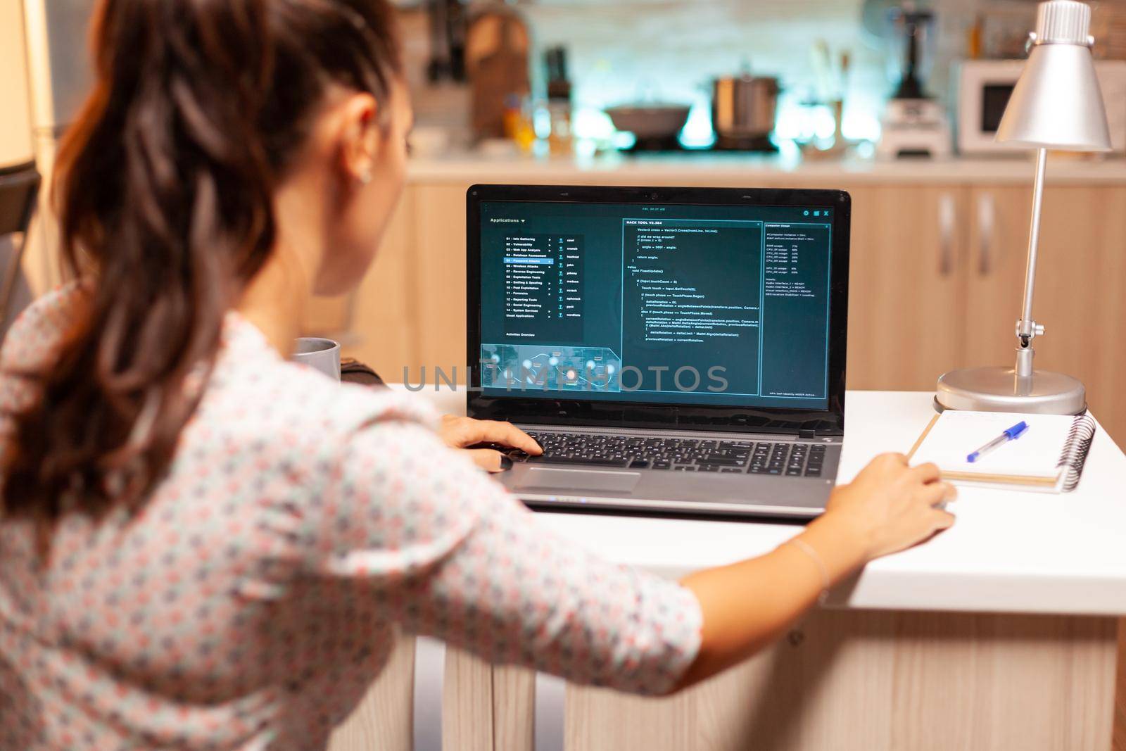Female hacker sitting in front of computer and thinking how to fraud the government at night time. Programmer writing a dangerous malware for cyber attacks using performance laptop during midnight.