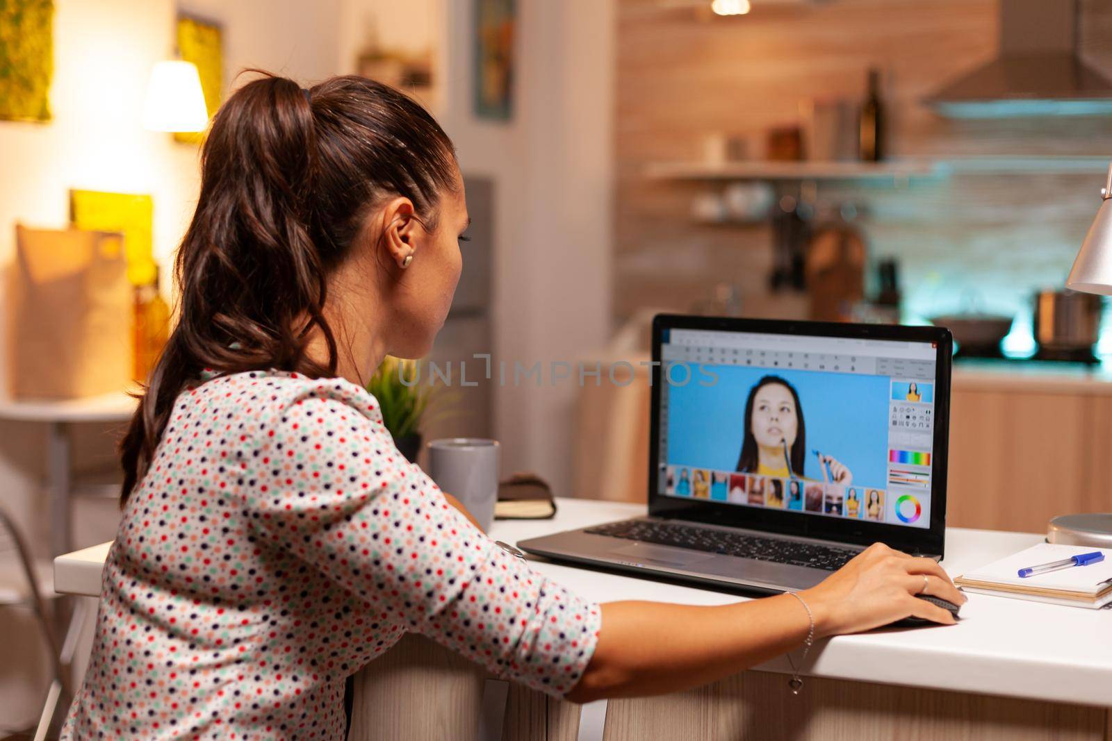 Woman digital editor work in photo editing software on her personal computer during night time. Photographer doing post production software and performance laptop, artist, occupation, screen, graphic.