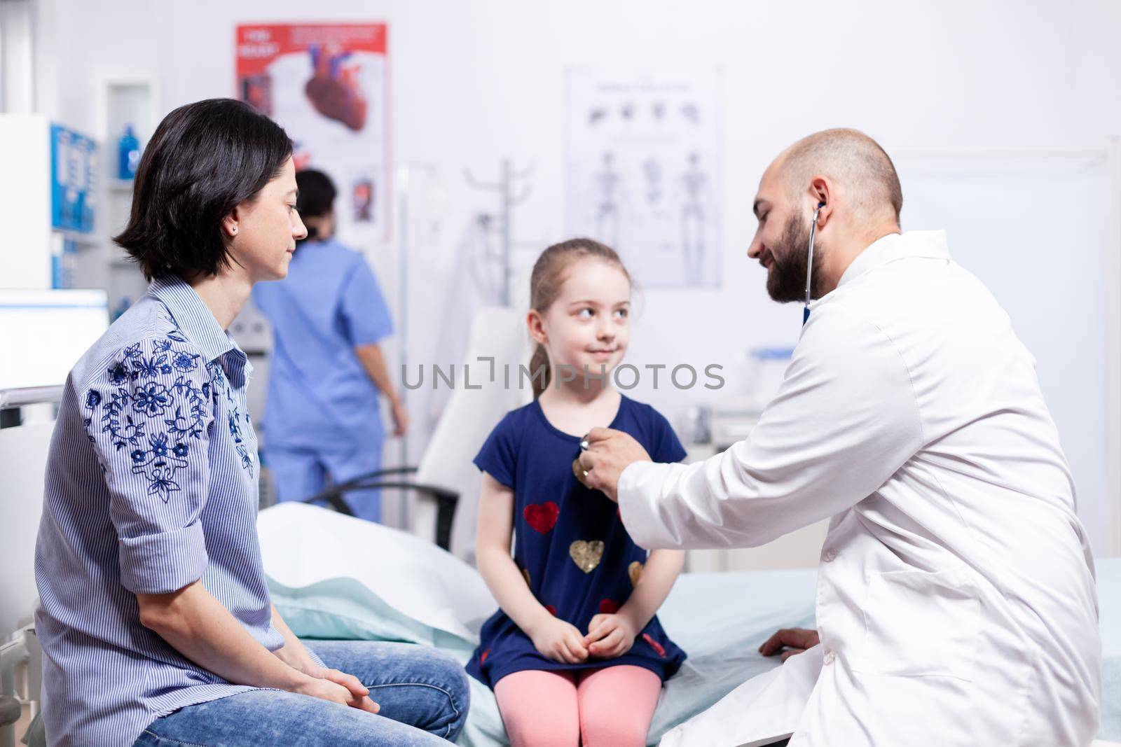 Pediatrician checking health of child using stethoscope in hospital office during consultation. Healthcare physician specialist in medicine providing health care services treatment examination.
