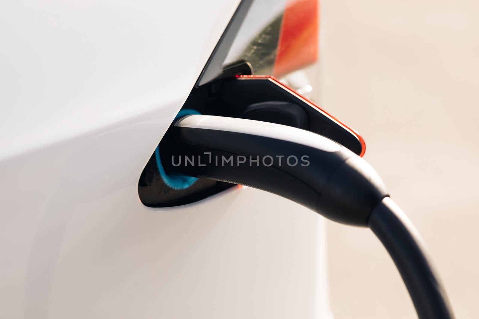 Electric vehicle charging port plugging in EV modern car. Color footage with a plug charging an electrical car. Save ecology alternative energy sustainable of future.
