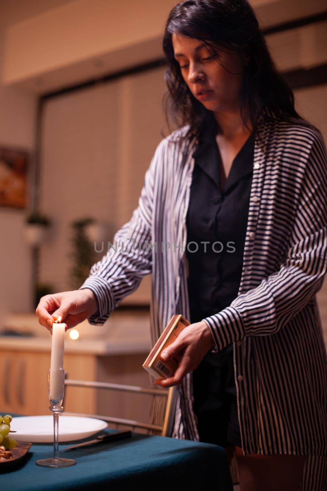 Young lady lighting the candle by DCStudio