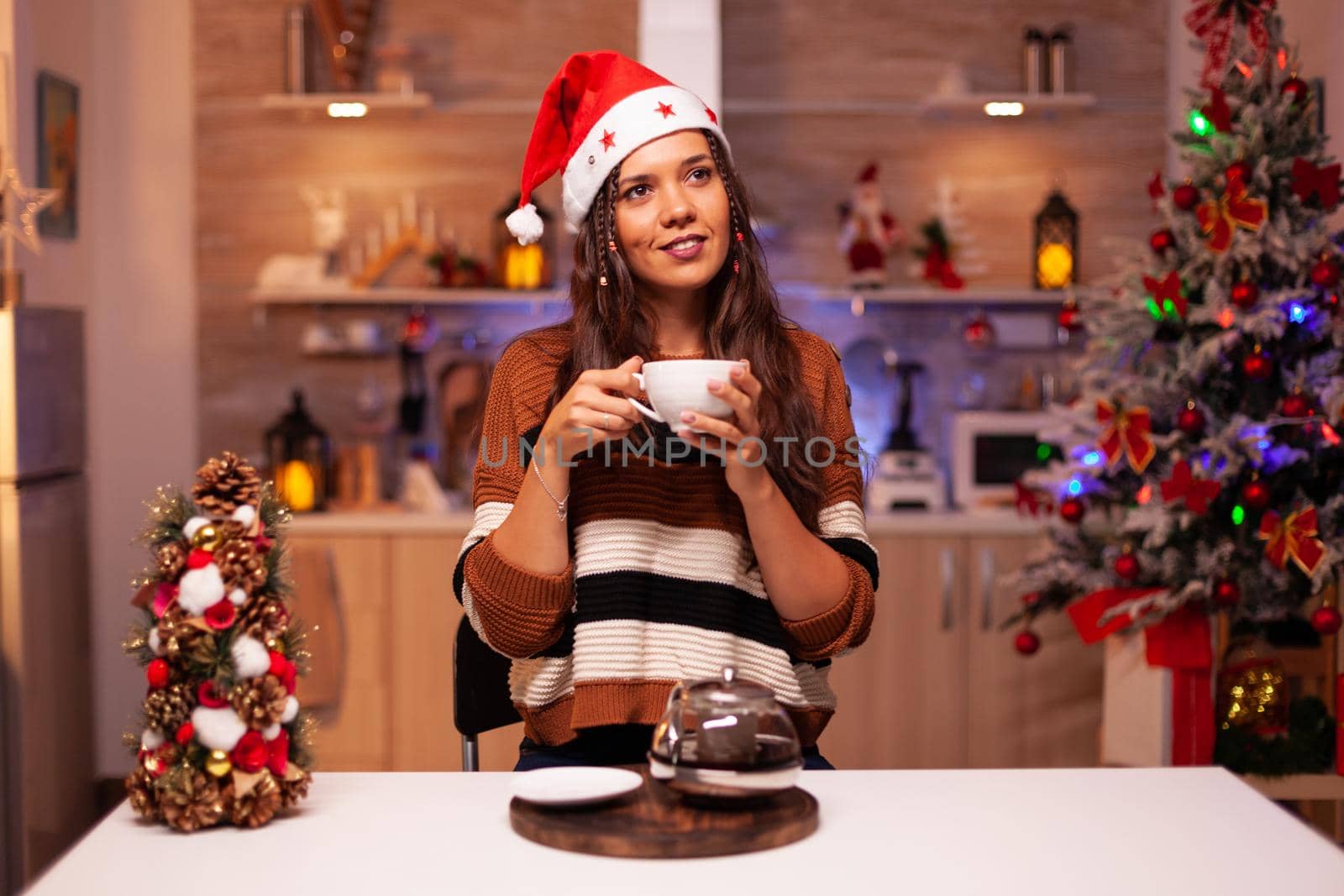 Portrait of young woman wearing santa hat and smiling by DCStudio