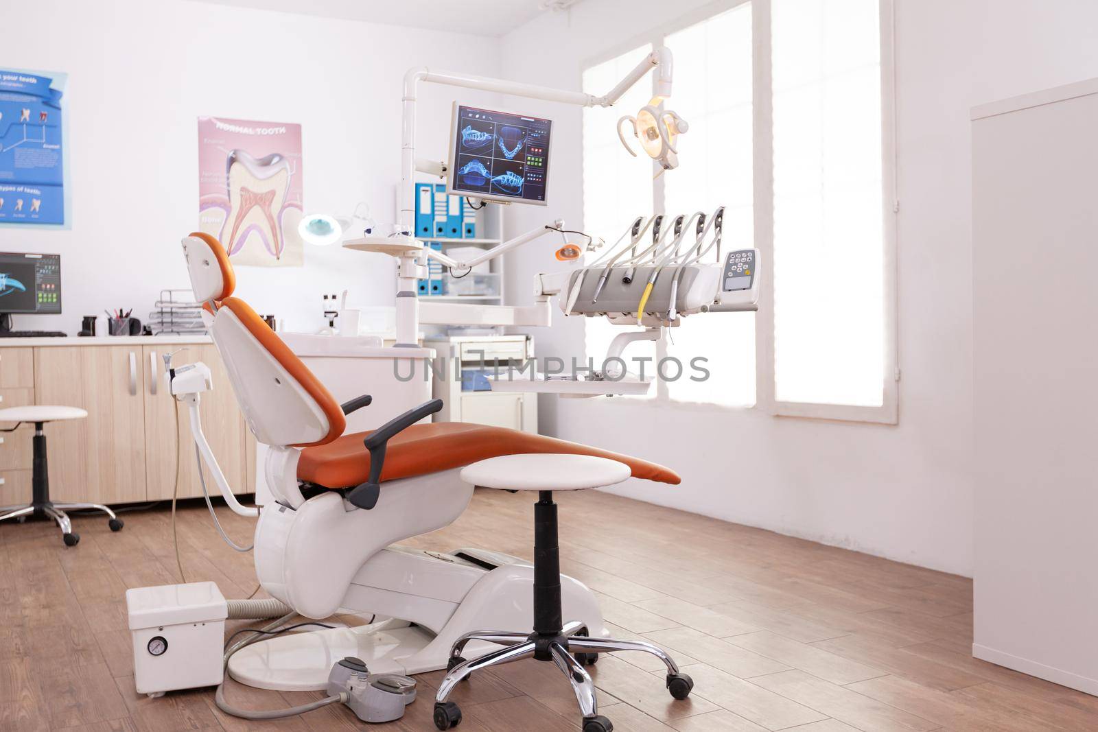 Empty stomatology orthodontist hospital office room equipped with teethcare instruments and dental medical chiarequipment. Orthodontic cabinet prepared for dentistry healthcare treatment