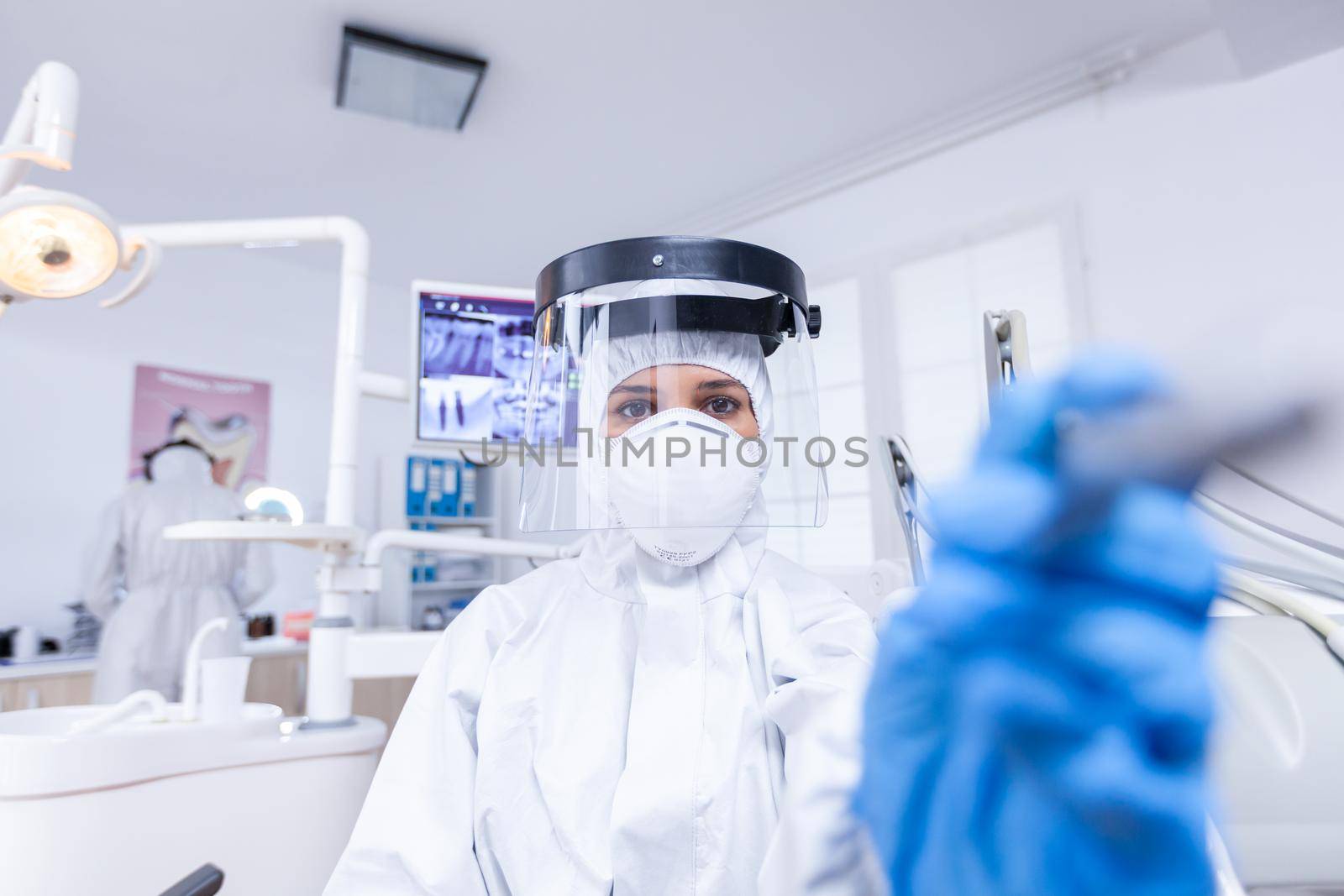 Patient pov of dentist in dental office treating tooth by DCStudio