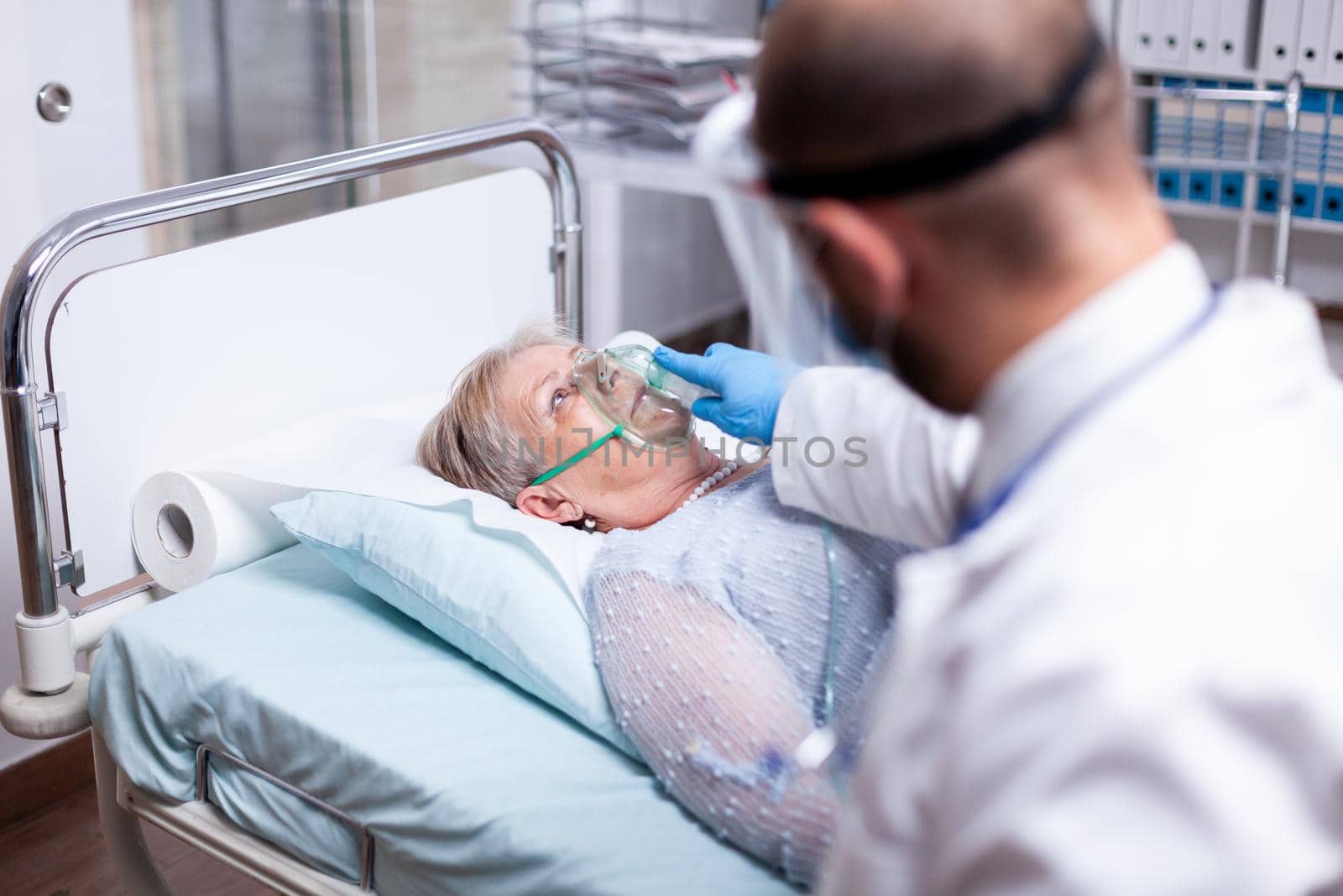 Patient breathing heavily without oxygen mask in emergency hospital room. Doctor helping old woman with pulmonary disease. Medicine medical healthcare system epidemic lungs infection treatment