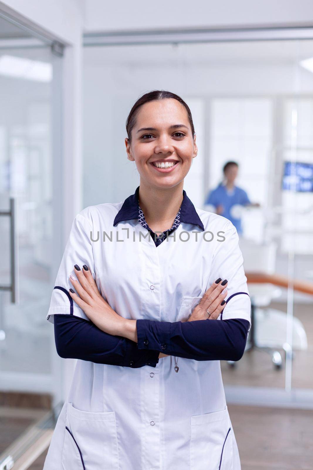 Portrait of teeth doctor in dental reception with arms crossed by DCStudio