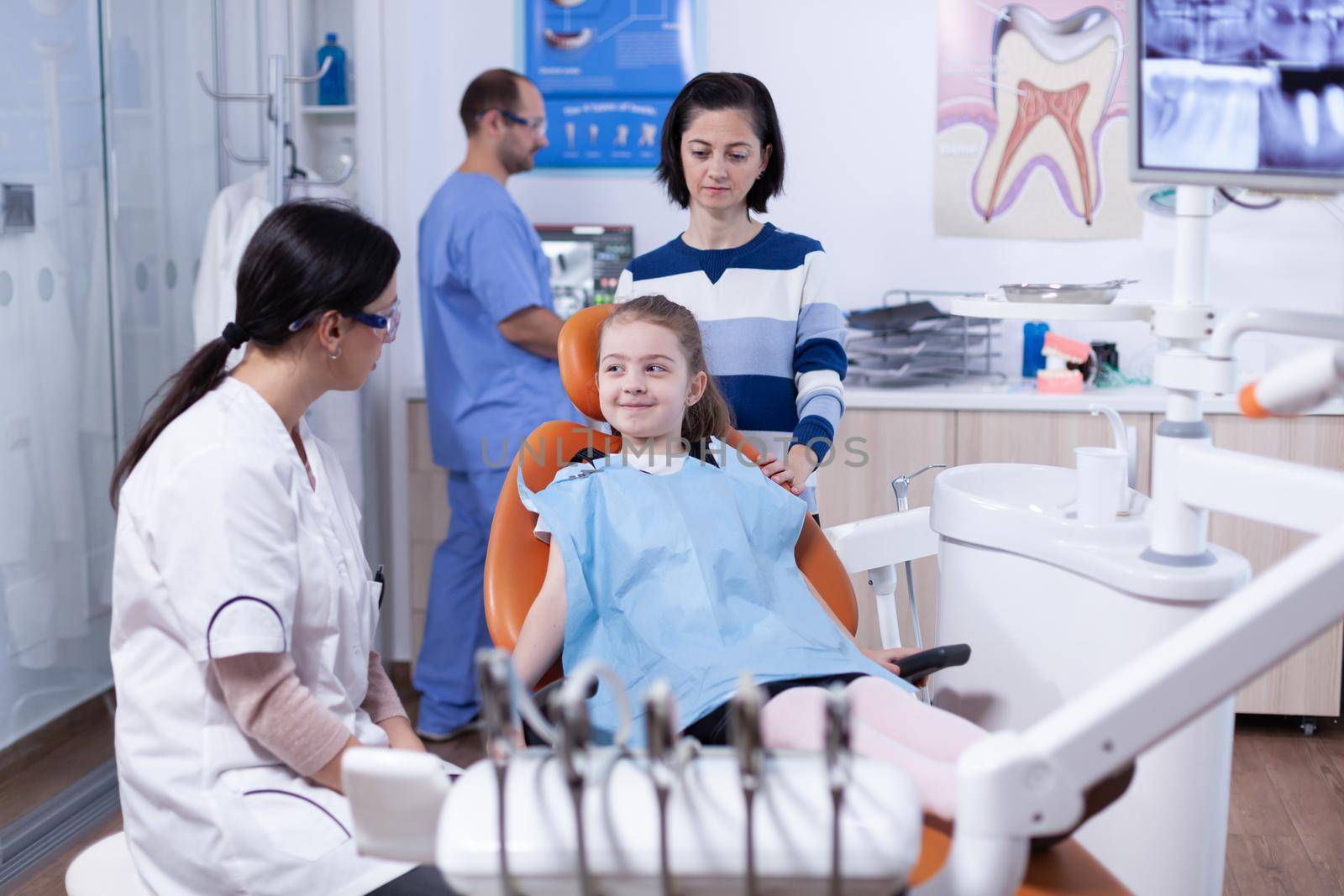 Little girl looking happy at dentist after professional tooth cavity treatment by DCStudio