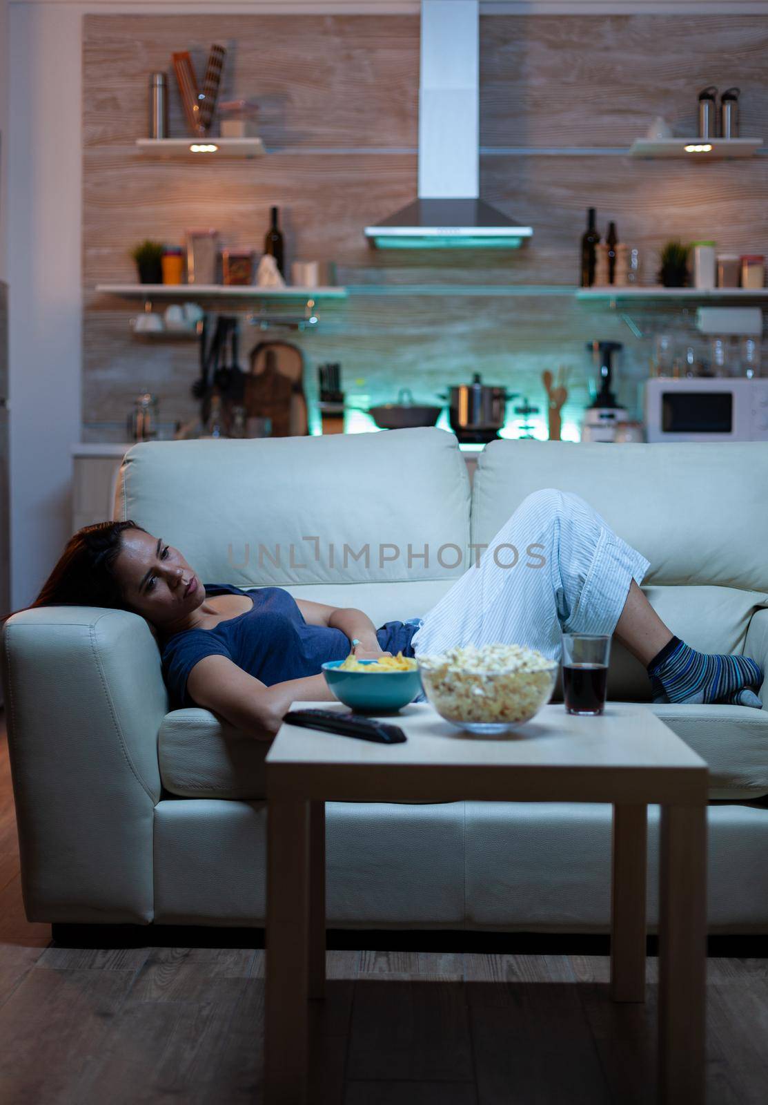 Exhausted woman watching tv show by DCStudio