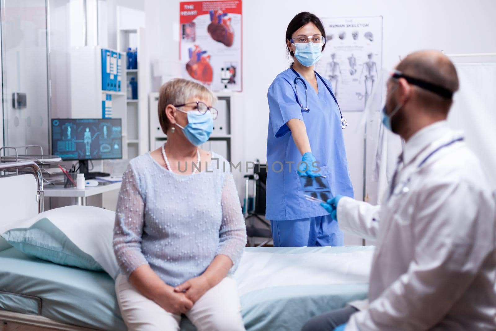 Nurse giving doctor x-ray by DCStudio