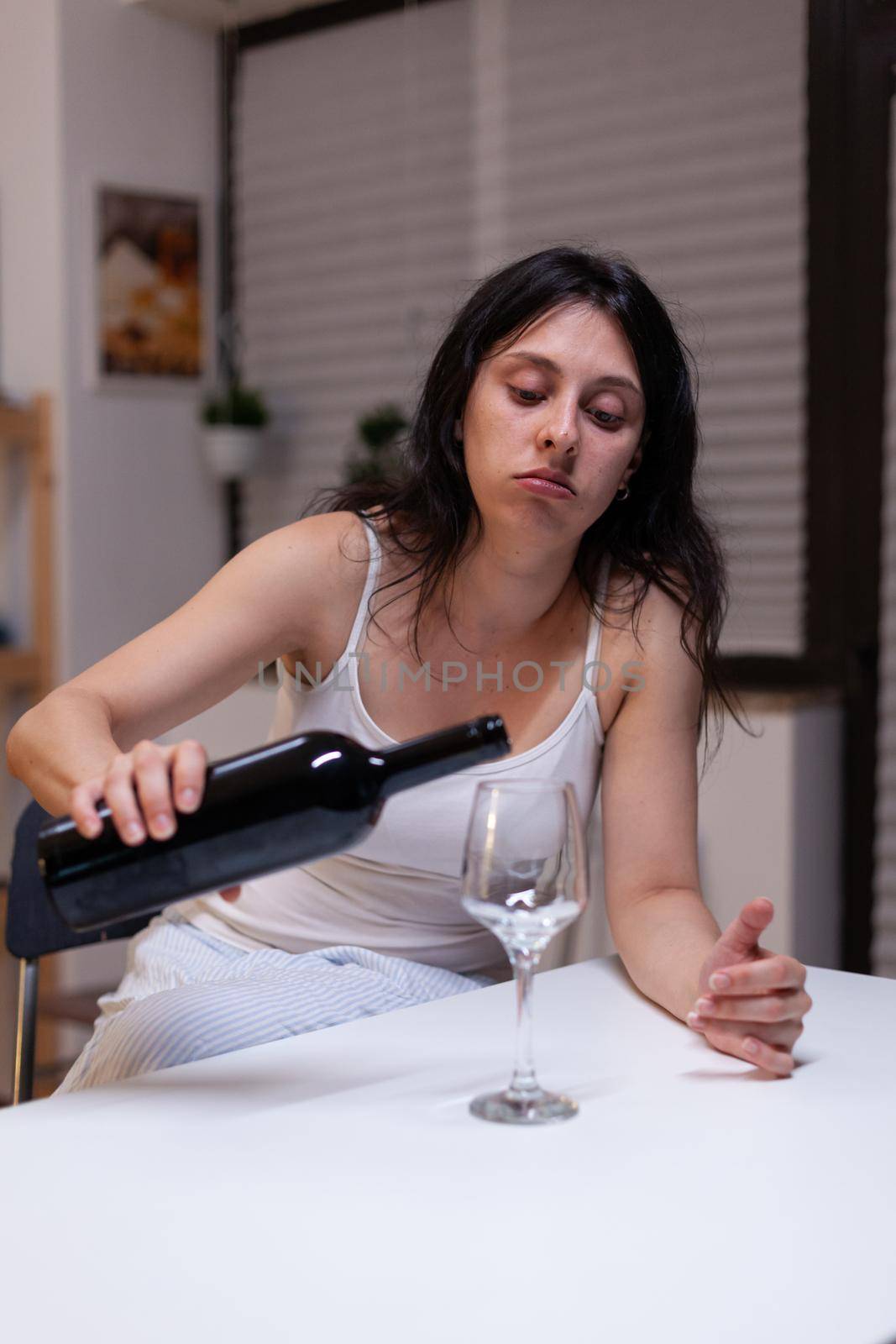 Alcoholic woman having bottle of wine and glass feeling sad by DCStudio