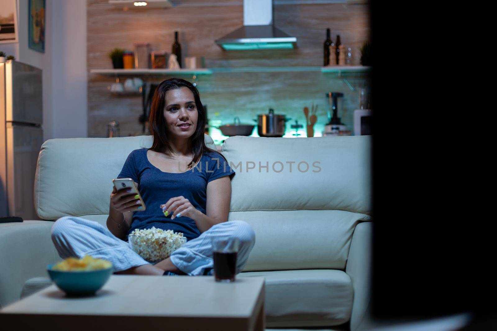 Lady using phone and watching tv by DCStudio