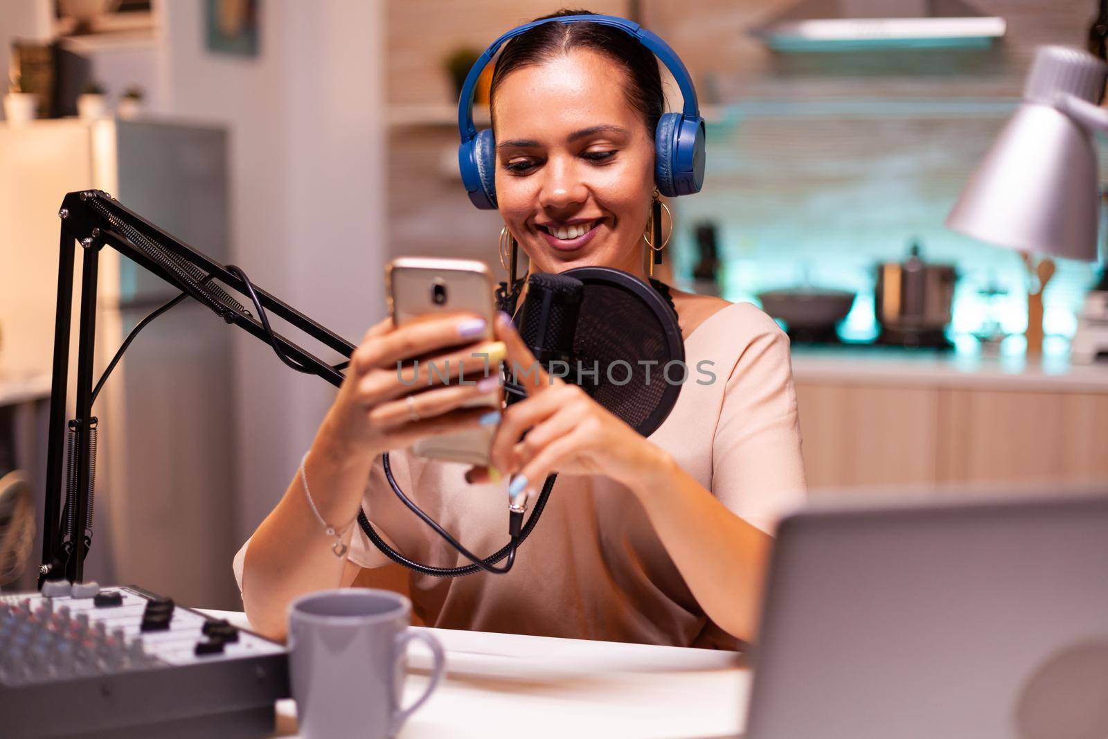 Famous influencer reading messages from fans on her phone during live on her social media. Creative online show On-air production internet broadcast host streaming live content.